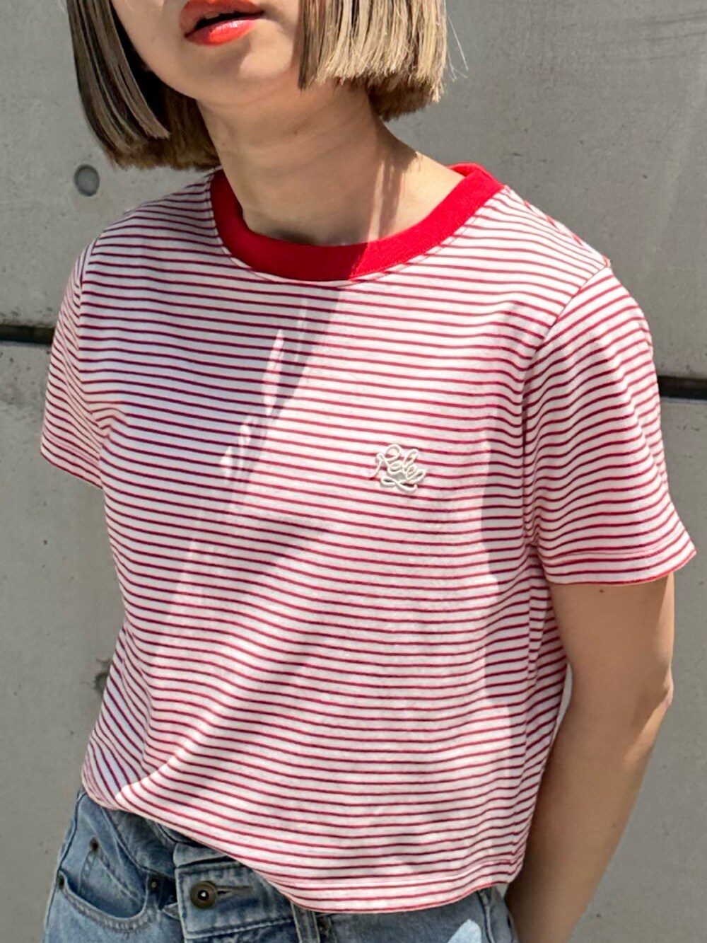 ブルー系のデニムパンツ、ブラック系のサンダル、ブラック系のショルダーバッグを着用したレディースの春コーディネートの3枚目の写真