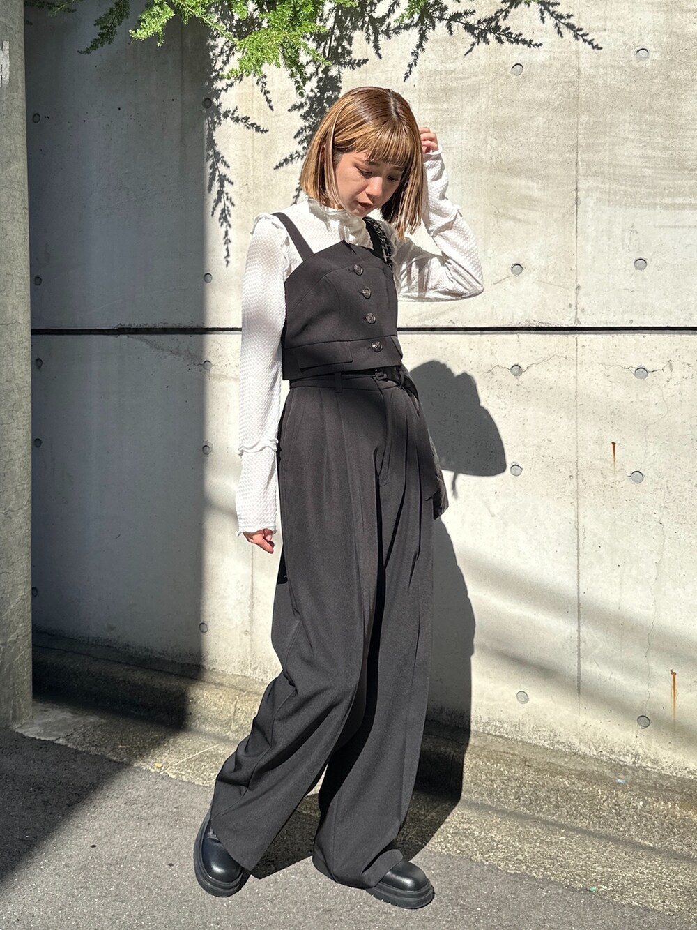 ブラック系のトートバッグ、ホワイト系のTシャツ/カットソー、ブラック系のベストを着用したレディースの秋コーディネートの2枚目の写真