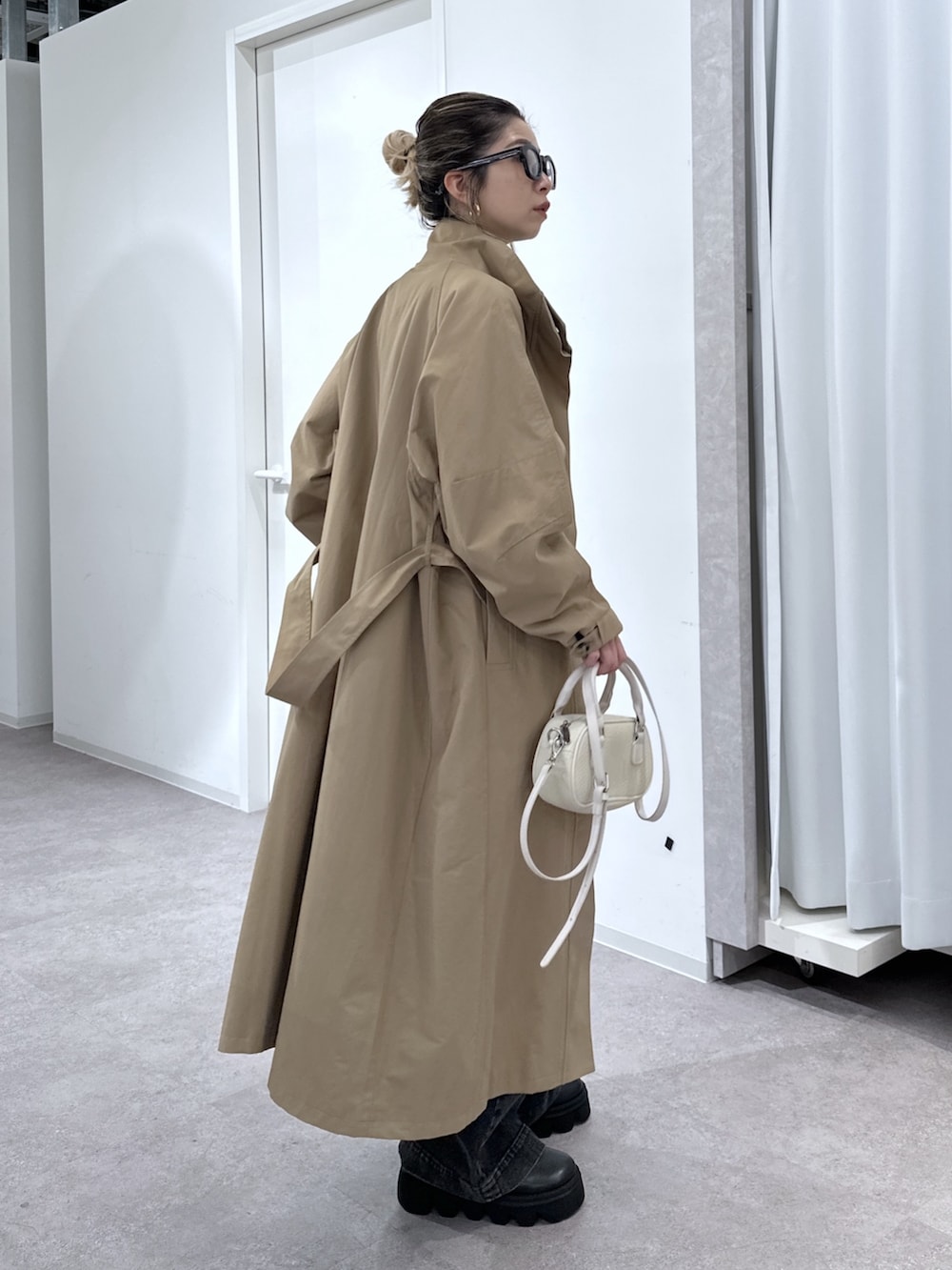 ブラック系のデニムパンツ、ブラック系のシャツ/ブラウス、ベージュ系のトレンチコートを着用したレディースの春コーディネートの2枚目の写真