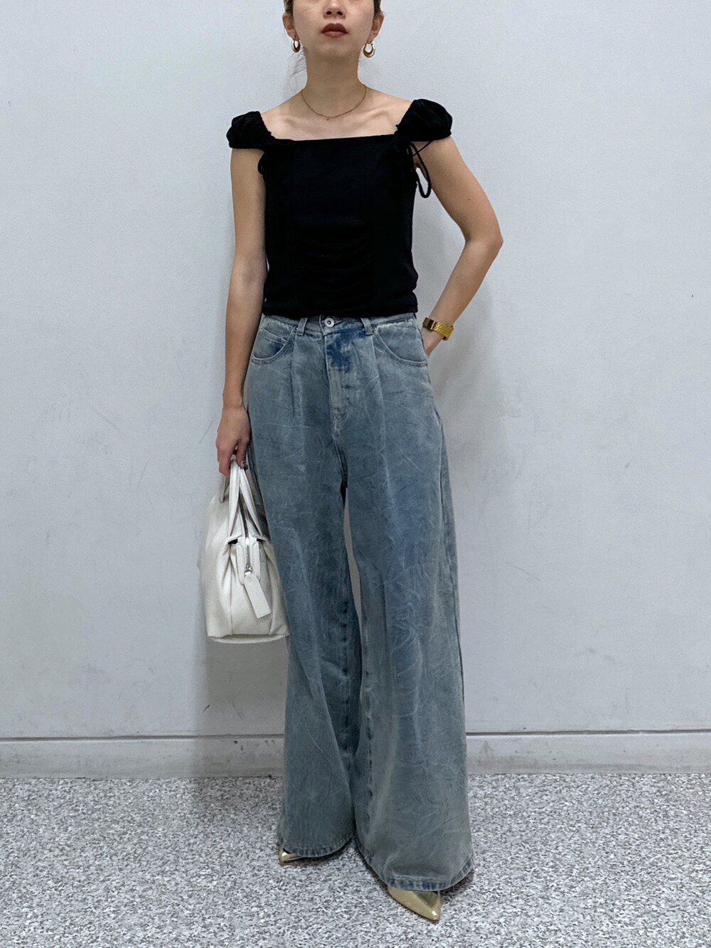 ブラック系のTシャツ/カットソー、ブルー系のデニムパンツ、ゴールド系のパンプスを着用したレディースの春コーディネートの7枚目の写真