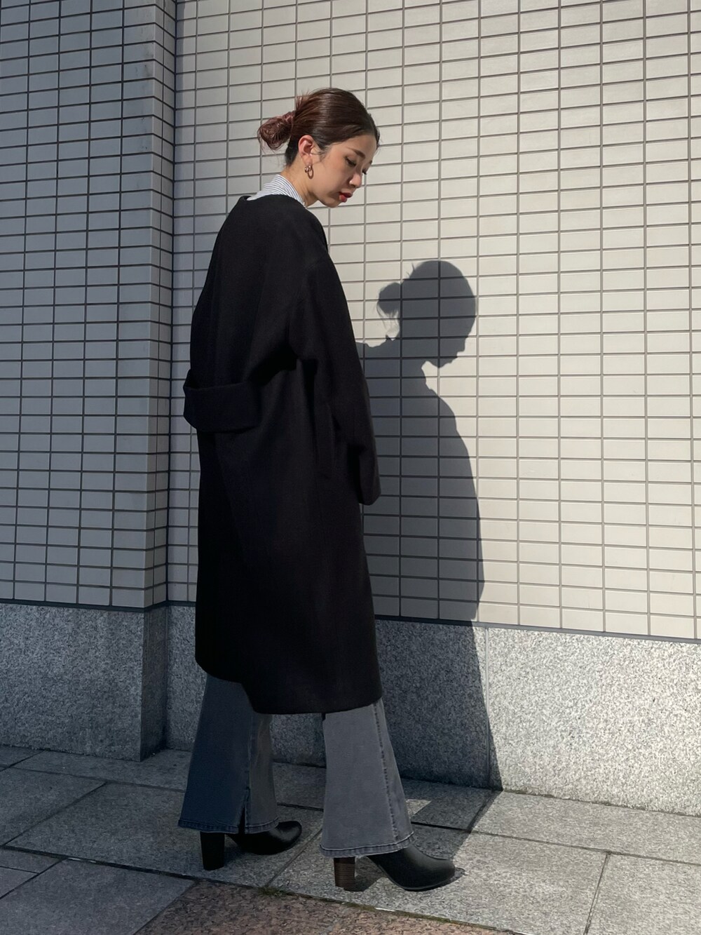 ブラック系のデニムパンツ、ブラック系のノーカラーコートを着用したレディースの夏コーディネートの4枚目の写真