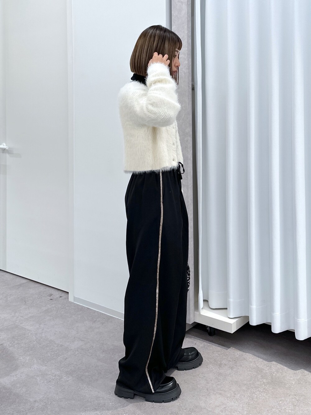 ブラック系のその他パンツ、ブラック系のハンドバッグ、ホワイト系のカーディガン/ボレロを着用したレディースの冬コーディネートの5枚目の写真