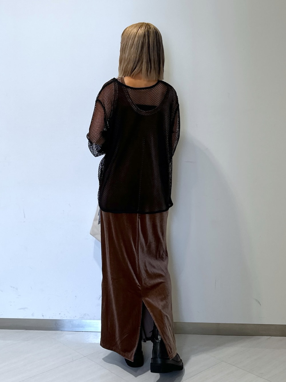 ブラウン系のワンピース、ブラック系のTシャツ/カットソー、ホワイト系のトートバッグを着用したレディースの秋コーディネートの2枚目の写真