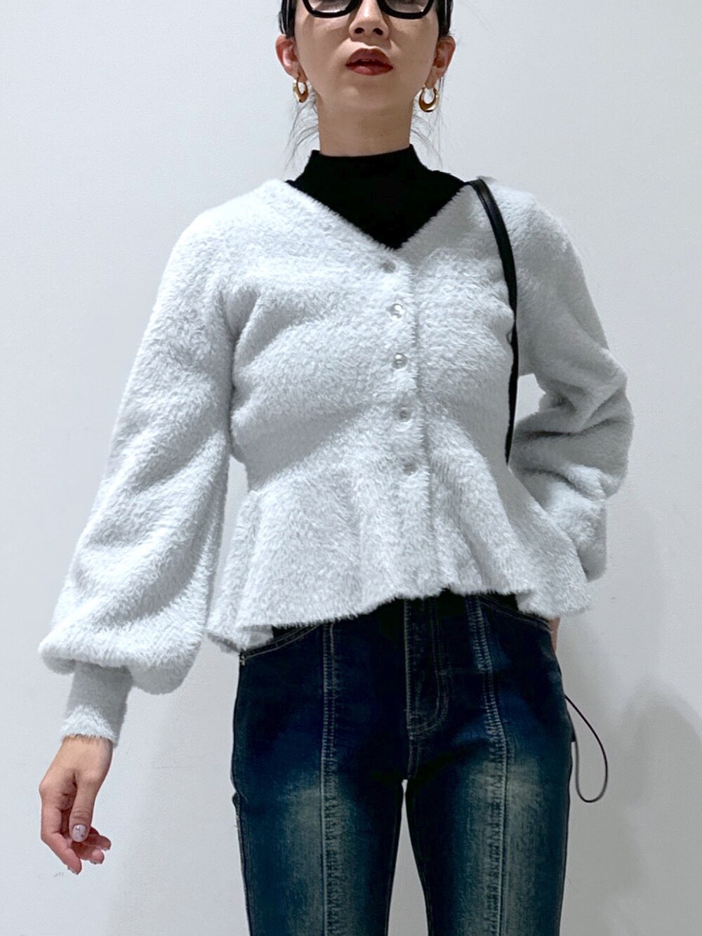 グレー系のカーディガン/ボレロ、ブラック系のニット/セーター、ブルー系のデニムパンツを着用したレディースの冬コーディネートの4枚目の写真