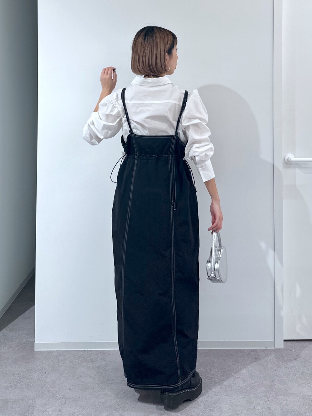 ホワイト系のシャツ/ブラウス、ブラック系のワンピース、シルバー系のショルダーバッグを着用したレディースの春コーディネートの3枚目の写真