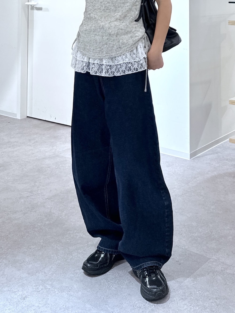 ホワイト系のTシャツ/カットソー、ブルー系のデニムパンツ、ブラック系のショルダーバッグを着用したレディースの夏コーディネートの3枚目の写真