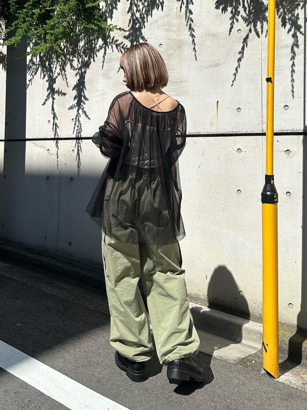 ブラック系のシャツ/ブラウス、グリーン系のカーゴパンツを着用したレディースの夏コーディネートの4枚目の写真