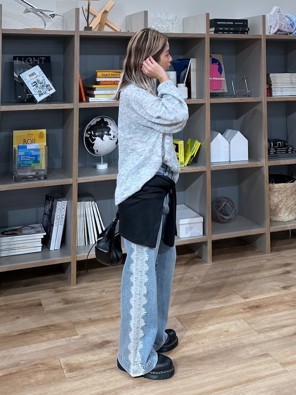 グレー系のニット/セーター、ブラック系のショルダーバッグ、ブラック系のTシャツ/カットソーを着用したレディースの秋コーディネートの2枚目の写真