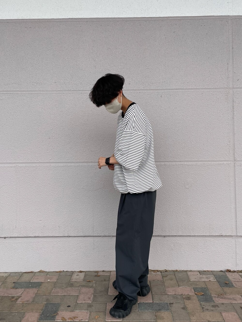 ホワイト系のTシャツ/カットソー、グレー系のその他パンツ、ブラック系のシューズを着用したメンズの夏コーディネートの2枚目の写真