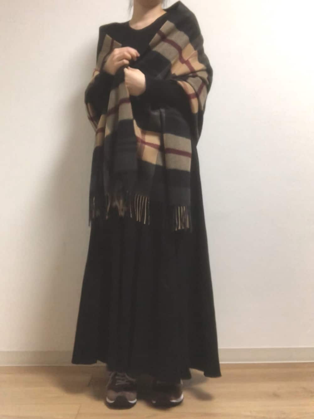 ブラウン系のスニーカー、ブラック系のワンピース、ベージュ系のストール/ショールを着用したレディースの冬コーディネートの2枚目の写真