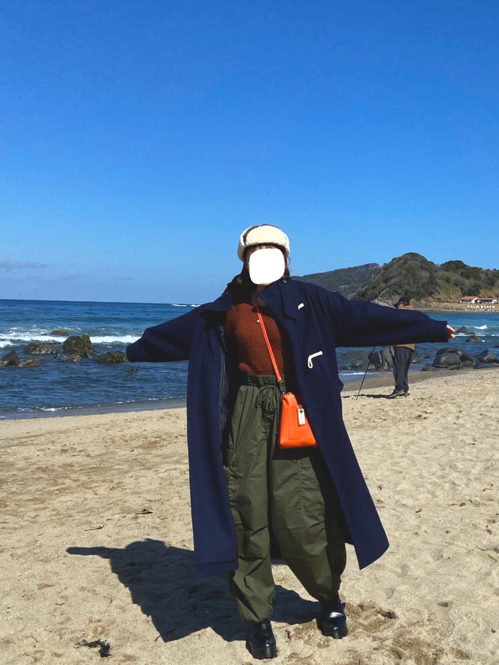 ブルー系のダッフルコート、ブラウン系のTシャツ/カットソー、オレンジ系のショルダーバッグを着用したレディースの冬コーディネートの2枚目の写真