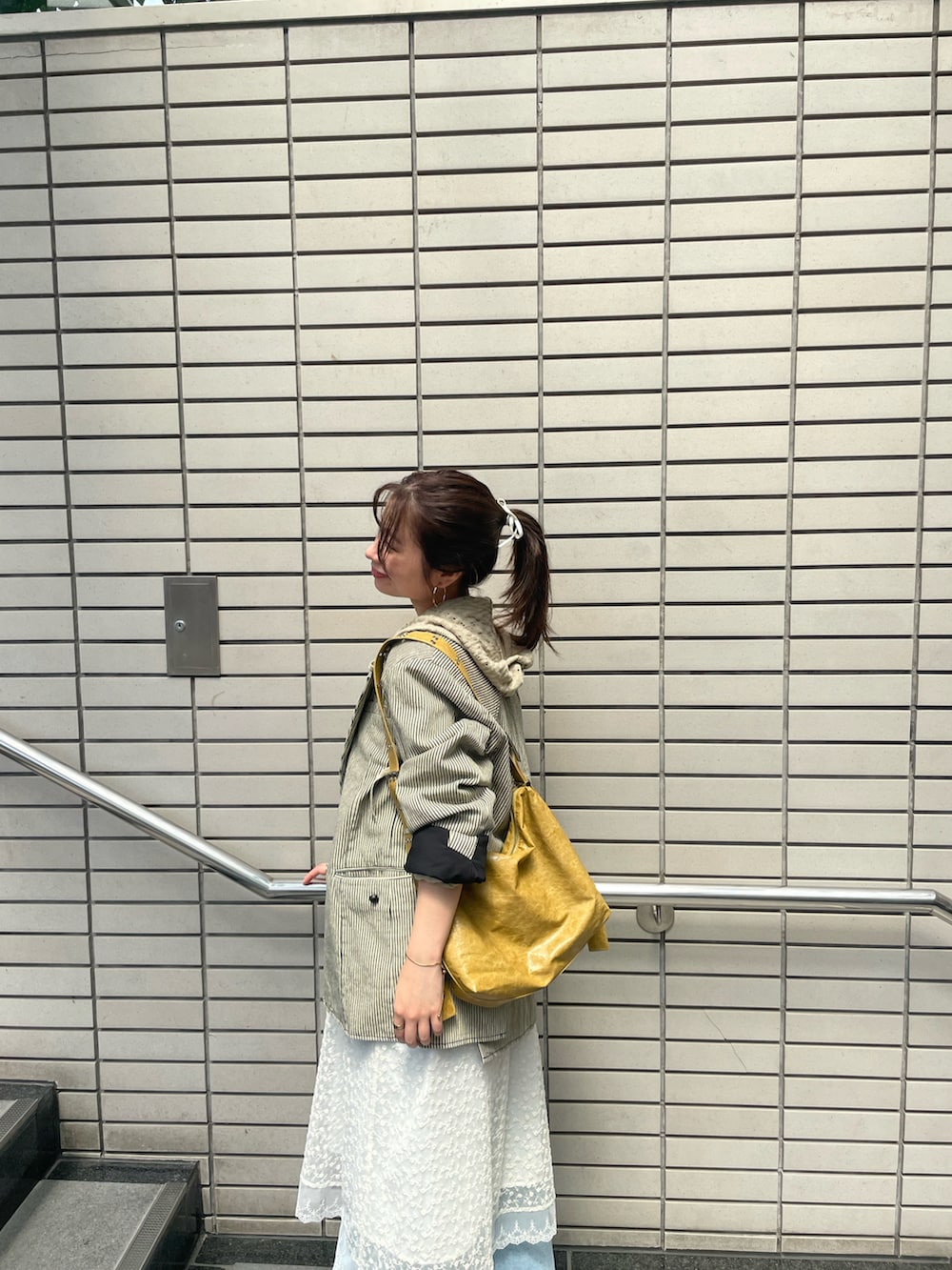 ベージュ系のワンピース、ベージュ系のパーカー、ブルー系のデニムパンツを着用したレディースの夏コーディネートの3枚目の写真