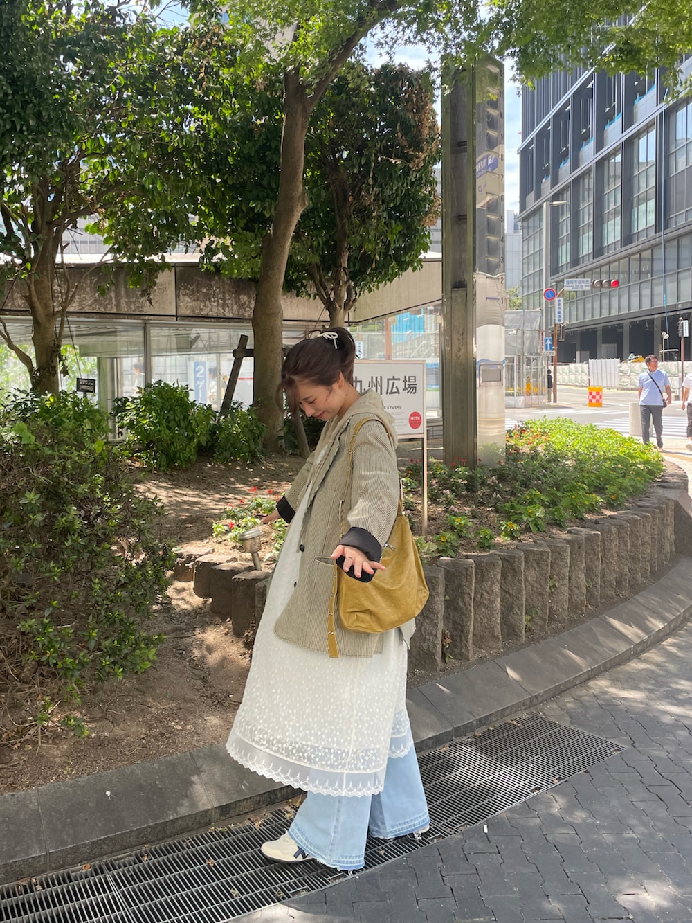 ベージュ系のワンピース、ベージュ系のパーカー、ブルー系のデニムパンツを着用したレディースの夏コーディネートの2枚目の写真