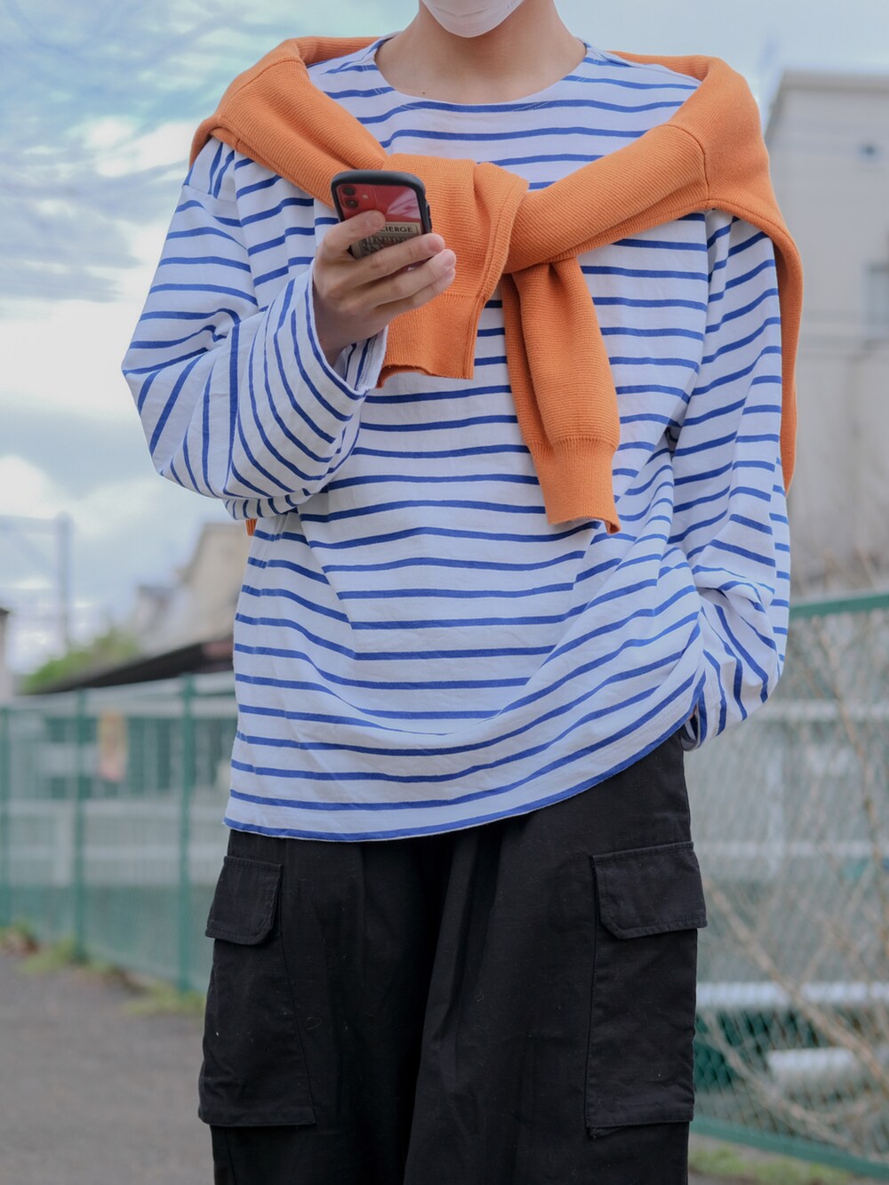 オレンジ系のカーディガン/ボレロ、ブルー系のTシャツ/カットソー、ブラック系のカーゴパンツを着用したメンズの春コーディネートの4枚目の写真