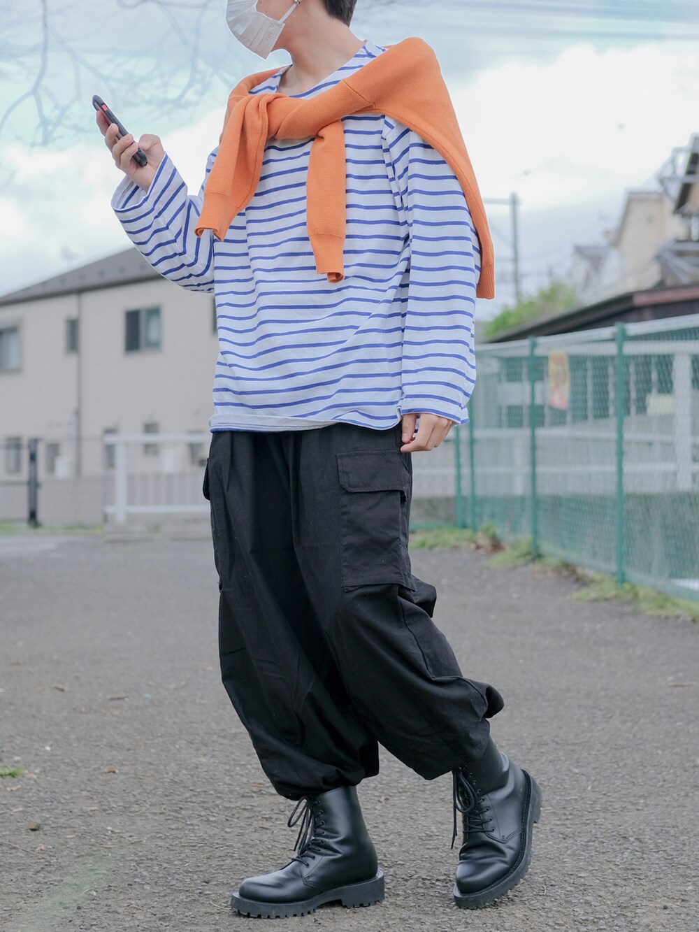 オレンジ系のカーディガン/ボレロ、ブルー系のTシャツ/カットソー、ブラック系のカーゴパンツを着用したメンズの春コーディネートの2枚目の写真