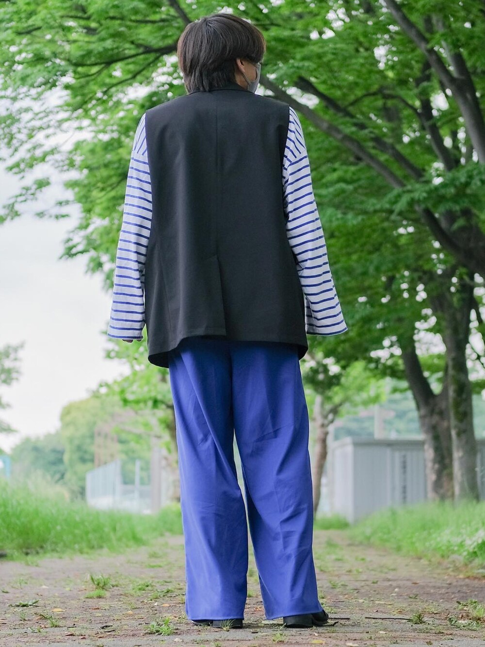 ブルー系のTシャツ/カットソー、ブルー系のパンツ、ブラック系のその他アウターを着用したメンズの春コーディネートの5枚目の写真