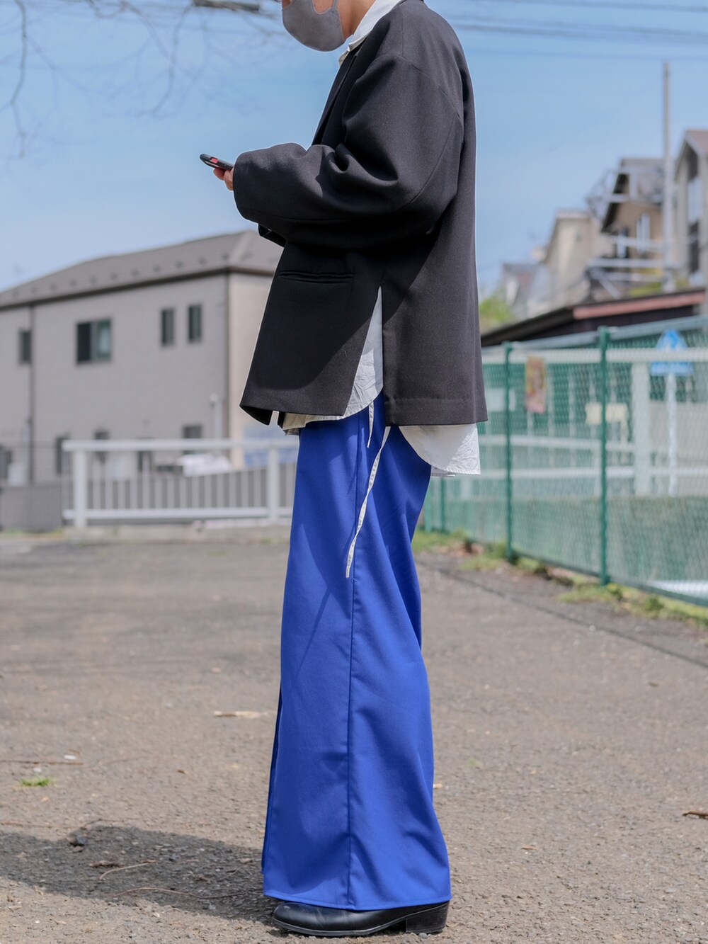 ブラック系のテーラードジャケット、ホワイト系のシャツ/ブラウス、ブルー系のパンツを着用したメンズの春コーディネートの2枚目の写真