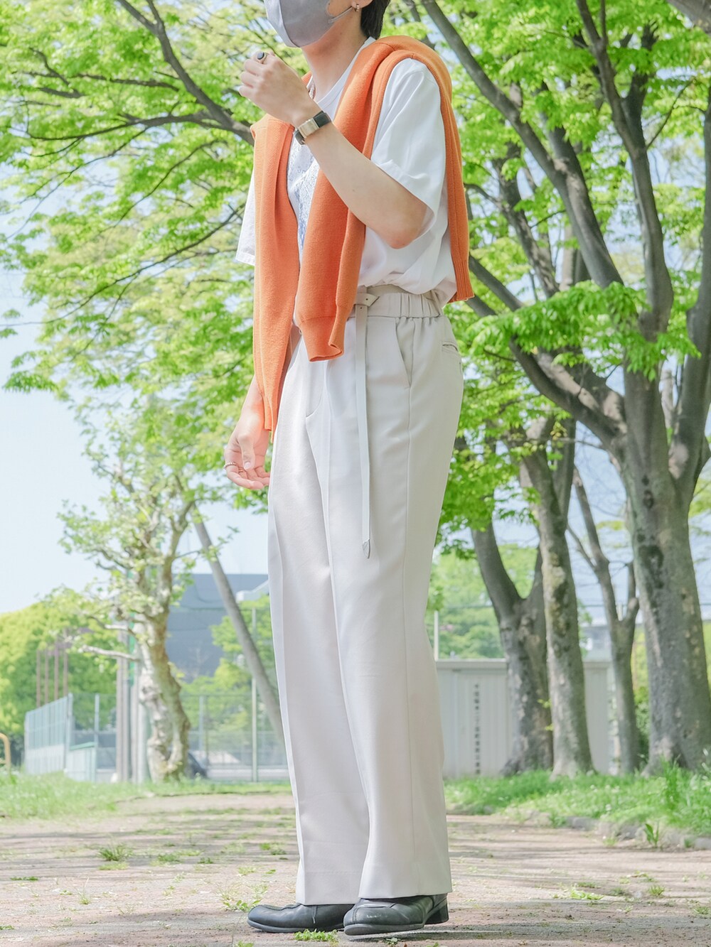 オレンジ系のカーディガン/ボレロ、ベージュ系のスラックス、ブラック系のドレスシューズを着用したメンズの春コーディネートの3枚目の写真