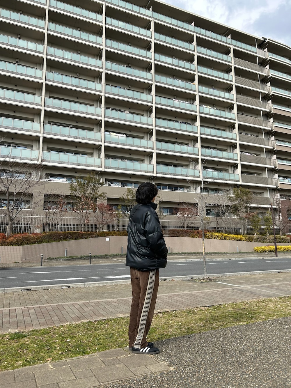 ブラック系のダウンジャケット/コート、ブラック系のショルダーバッグ、ブラック系のスニーカーを着用したメンズの冬コーディネートの3枚目の写真