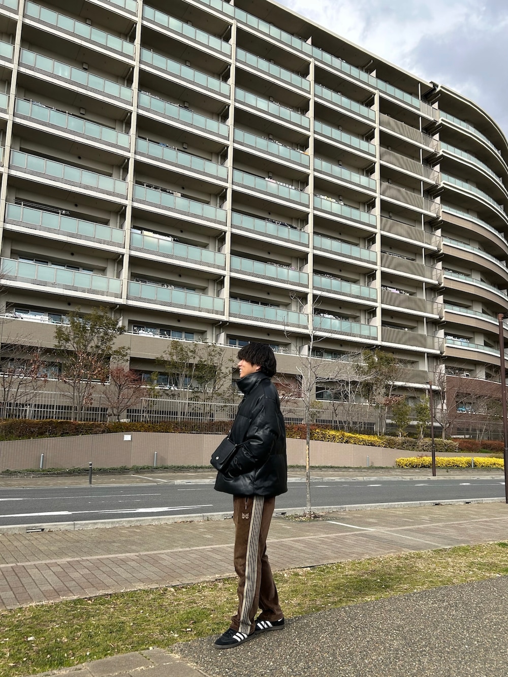 ブラック系のダウンジャケット/コート、ブラック系のショルダーバッグ、ブラック系のスニーカーを着用したメンズの冬コーディネートの2枚目の写真