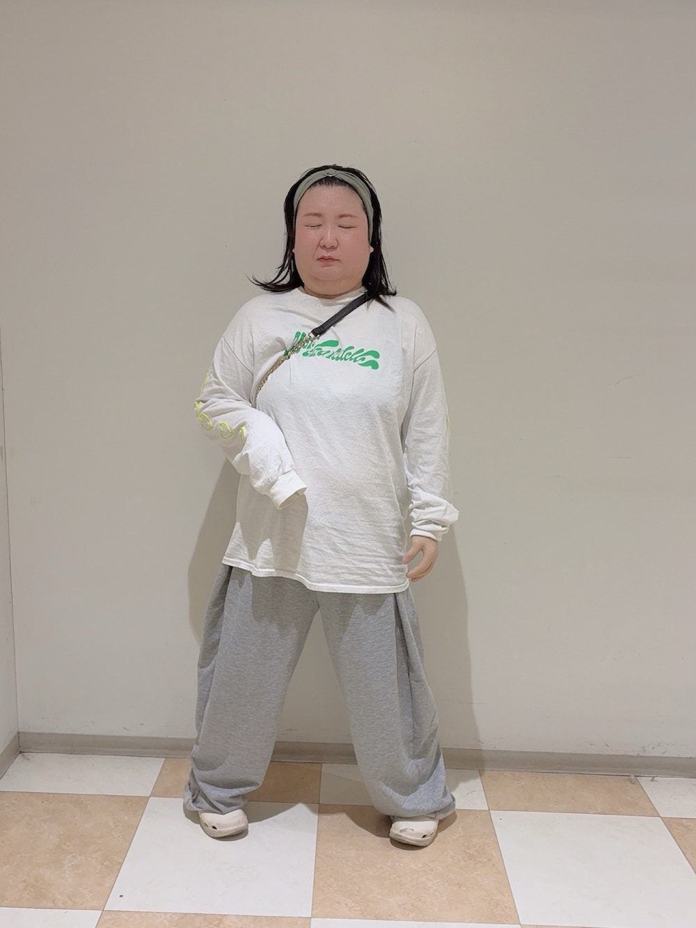 ホワイト系のTシャツ/カットソー、ホワイト系のサンダル、グリーン系のヘアバンドを着用したレディースの秋コーディネートの2枚目の写真