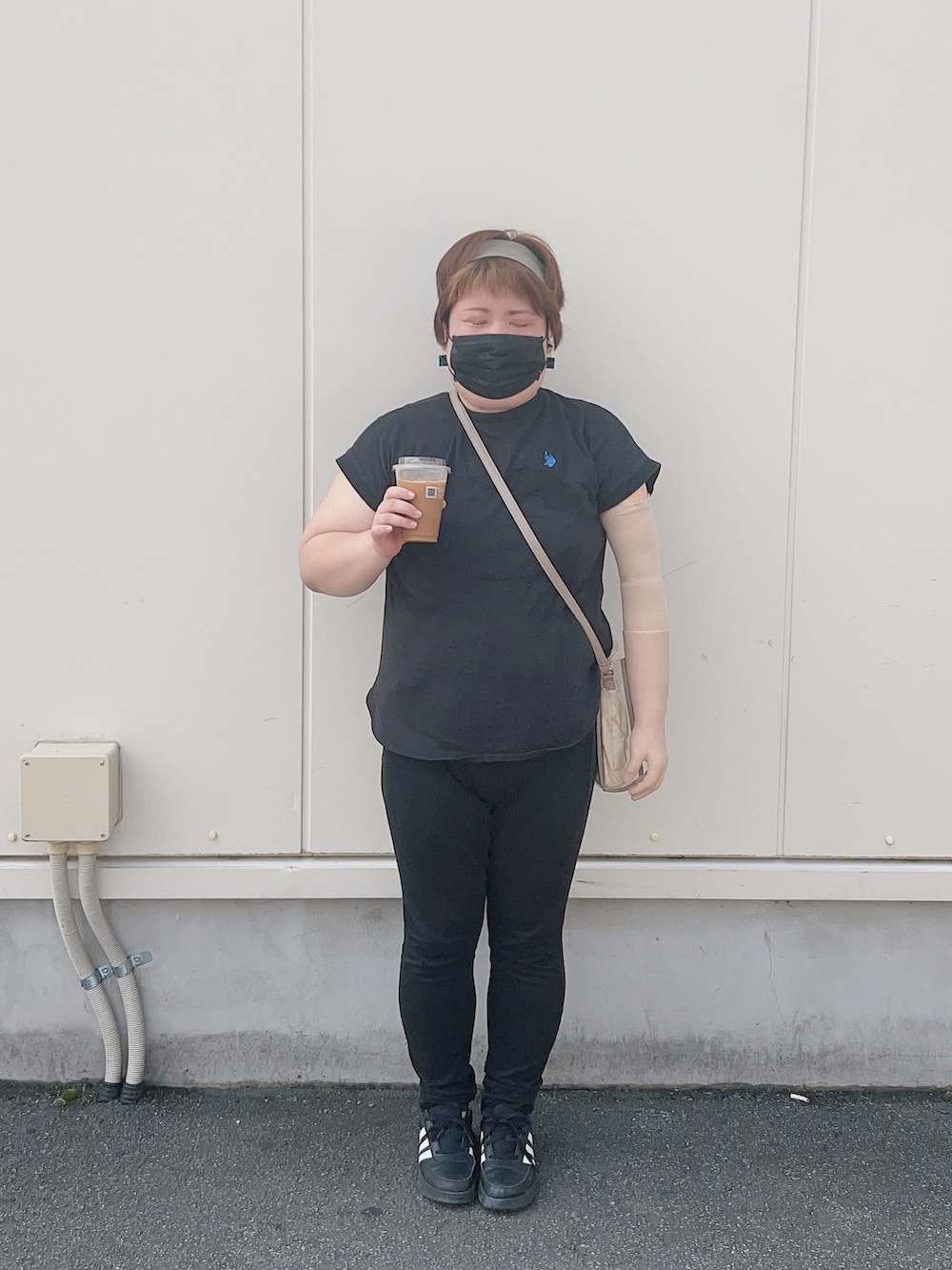 ブラック系のTシャツ/カットソー、ベージュ系のショルダーバッグ、ブラック系のデニムパンツを着用したレディースの夏コーディネートの3枚目の写真