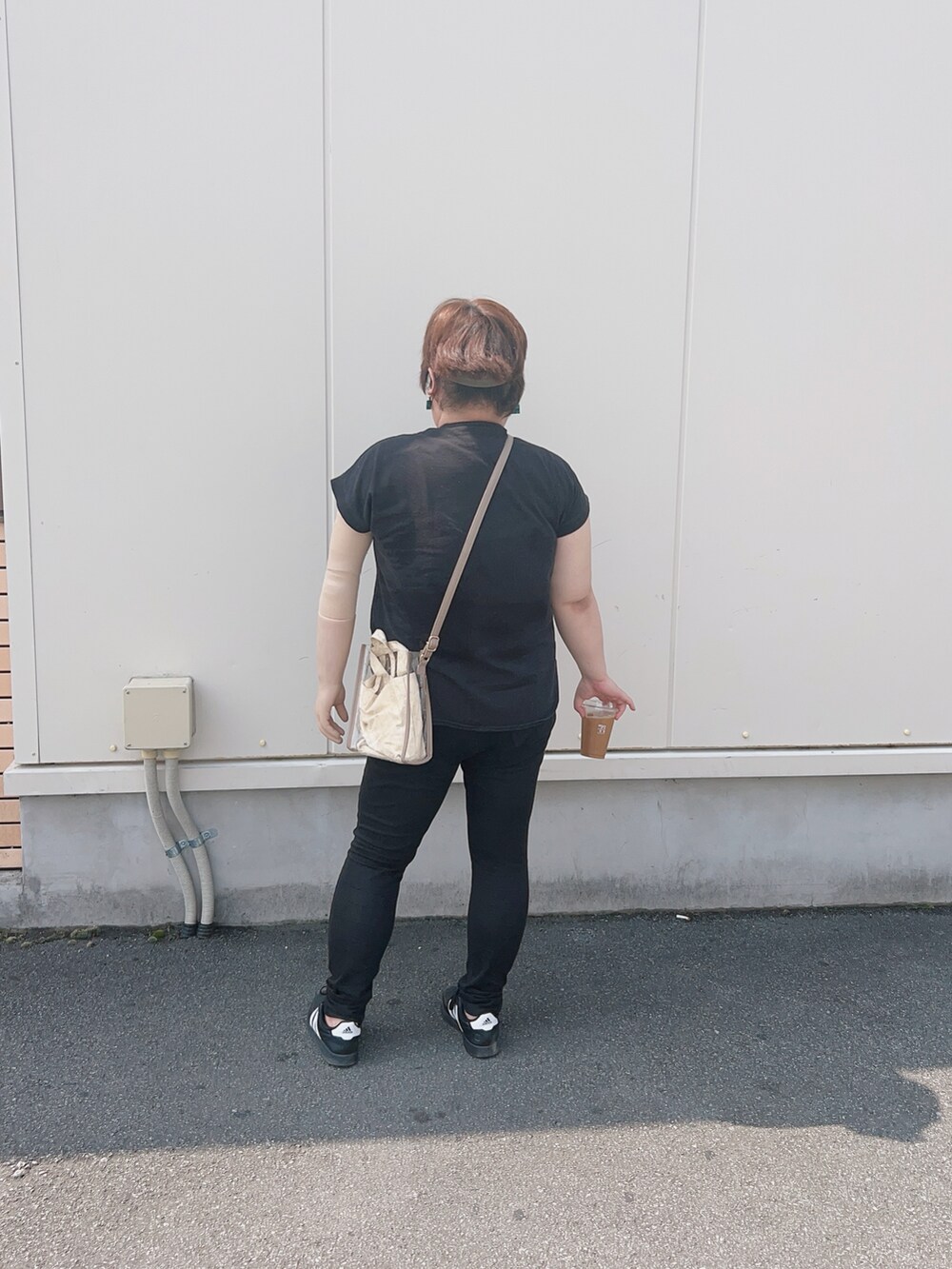 ブラック系のTシャツ/カットソー、ベージュ系のショルダーバッグ、ブラック系のデニムパンツを着用したレディースの夏コーディネートの4枚目の写真