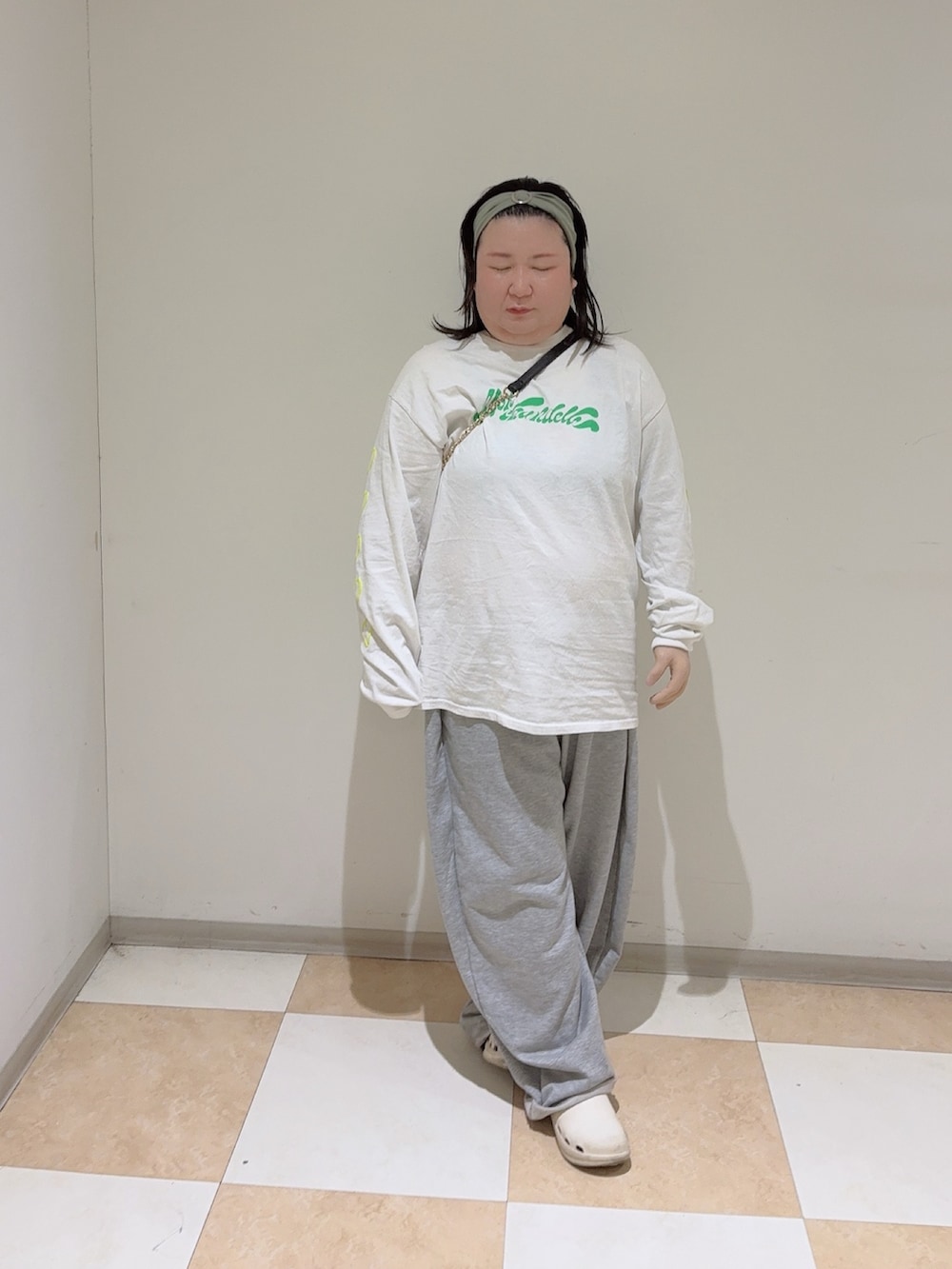 ホワイト系のTシャツ/カットソー、ホワイト系のサンダル、グリーン系のヘアバンドを着用したレディースの秋コーディネートの3枚目の写真