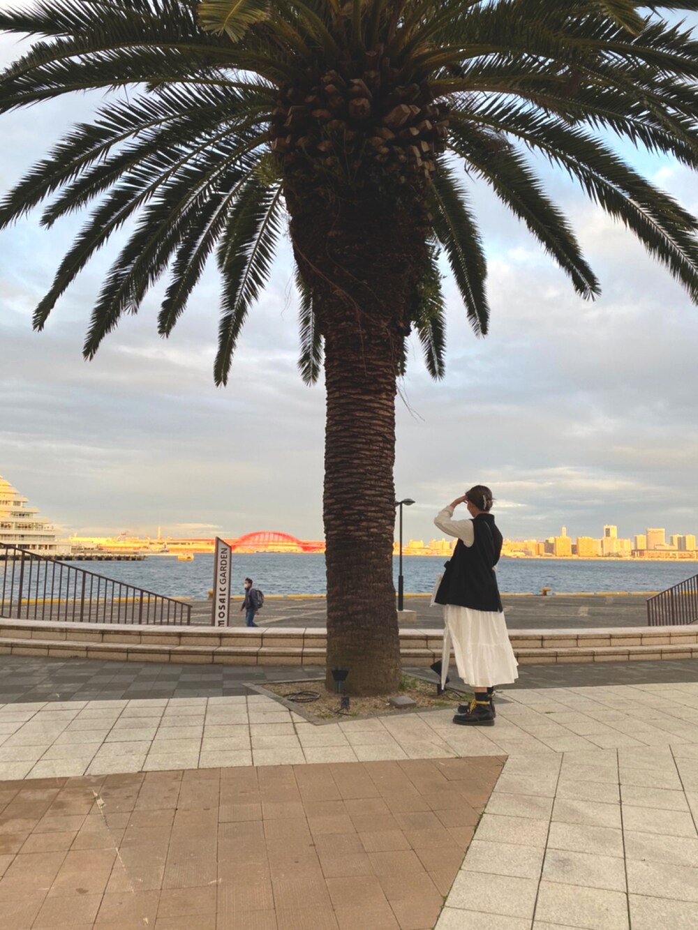 ブラック系のショルダーバッグ、ブラック系のブーツ、ホワイト系のシャツワンピースを着用したレディースの春コーディネートの2枚目の写真