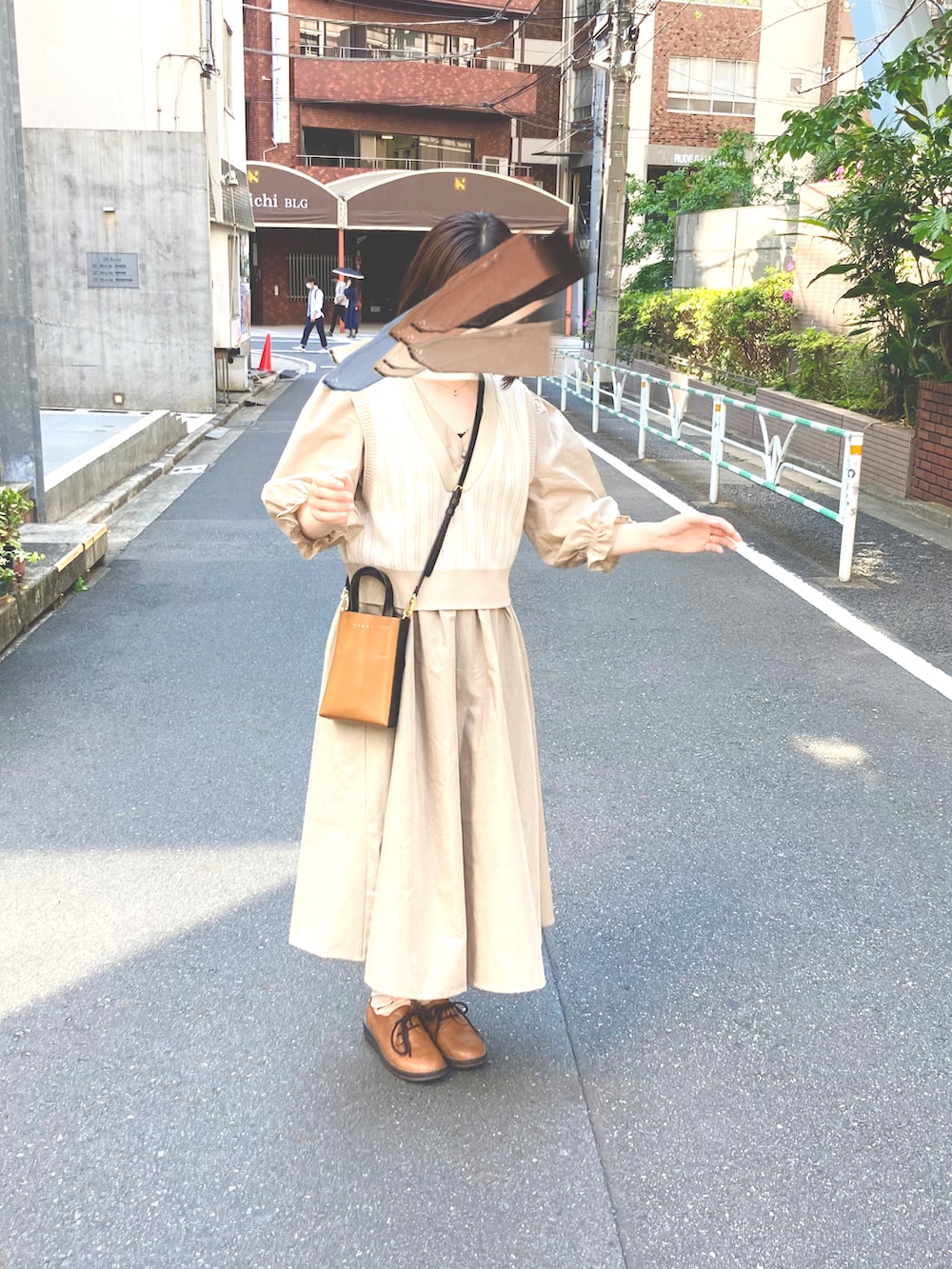 ベージュ系のベスト、ベージュ系のワンピース、ベージュ系のショルダーバッグを着用したレディースの春コーディネートの2枚目の写真