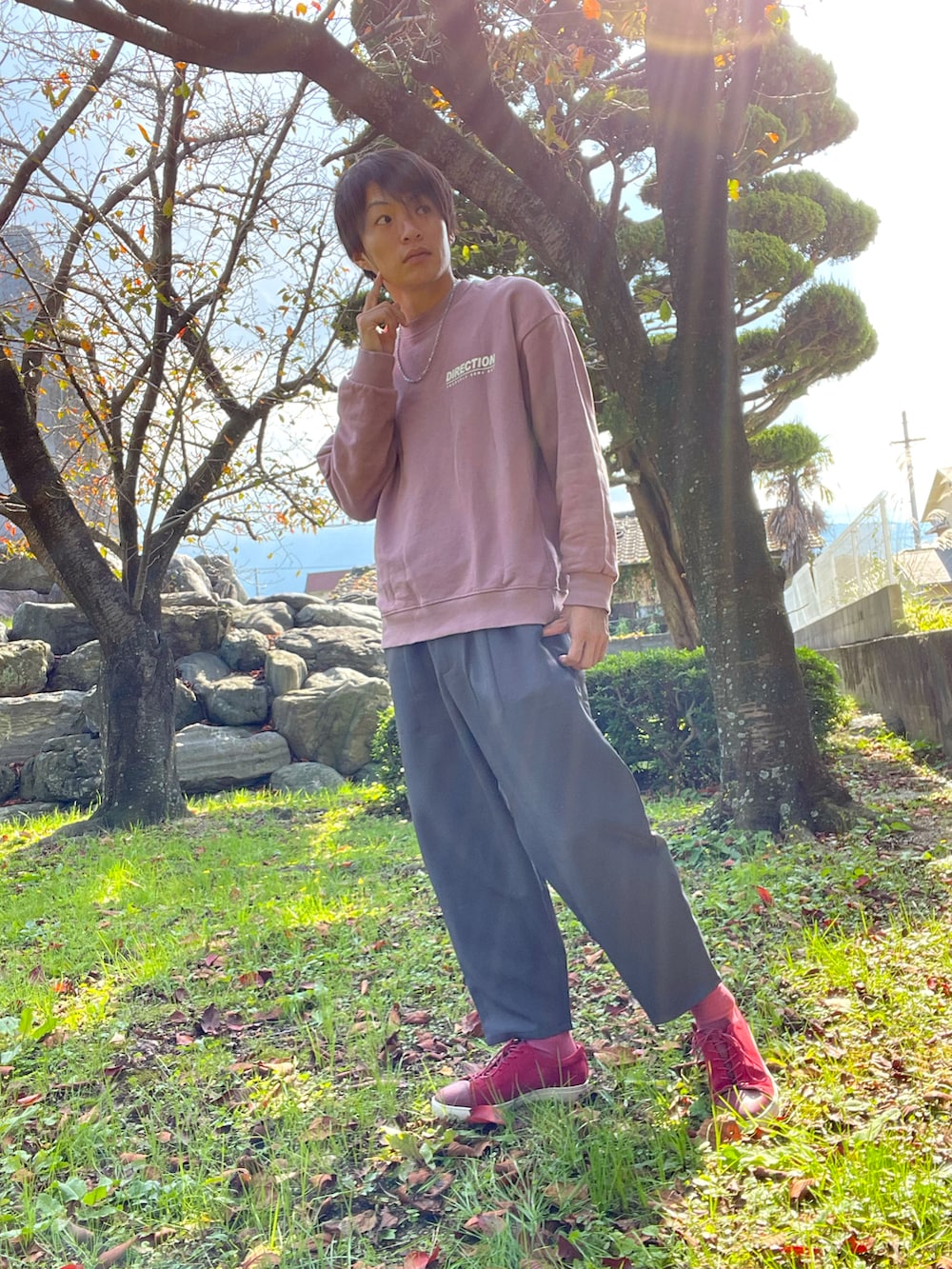 ピンク系のスウェット、グレー系のその他パンツ、レッド系のシューズを着用したメンズの秋コーディネートの2枚目の写真
