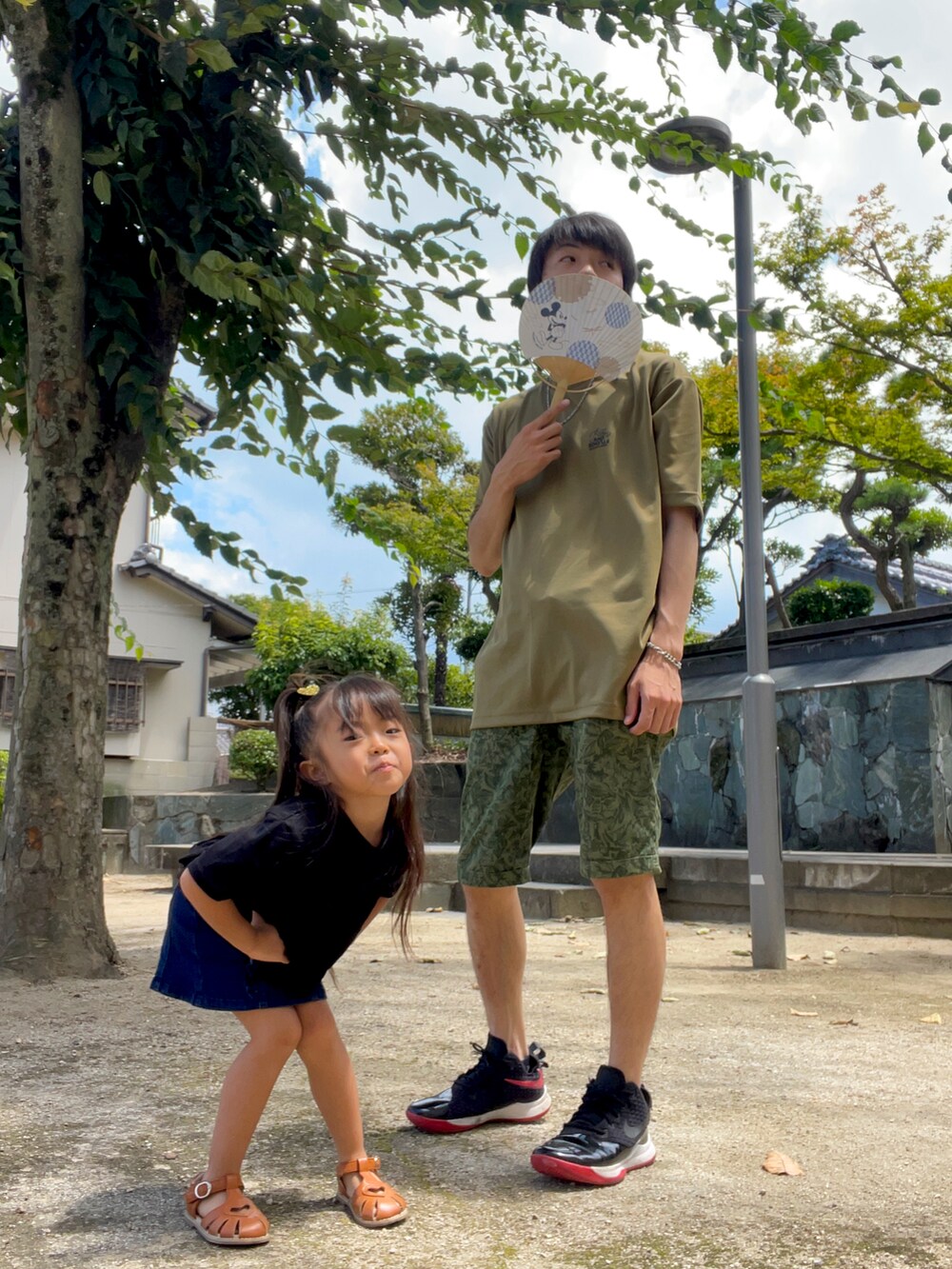 グリーン系のTシャツ/カットソー、グリーン系のパンツ、ブラック系のスニーカーを着用したメンズの夏コーディネートの2枚目の写真