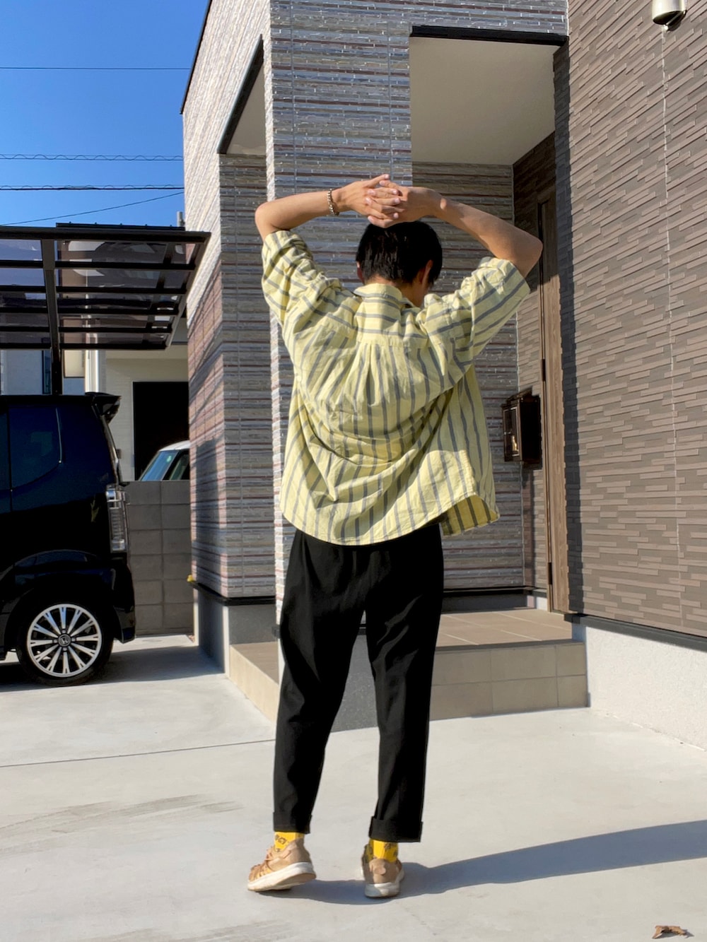 イエロー系のシャツ/ブラウス、ブラック系のTシャツ/カットソー、ブラウン系のサンダルを着用したメンズの秋コーディネートの2枚目の写真