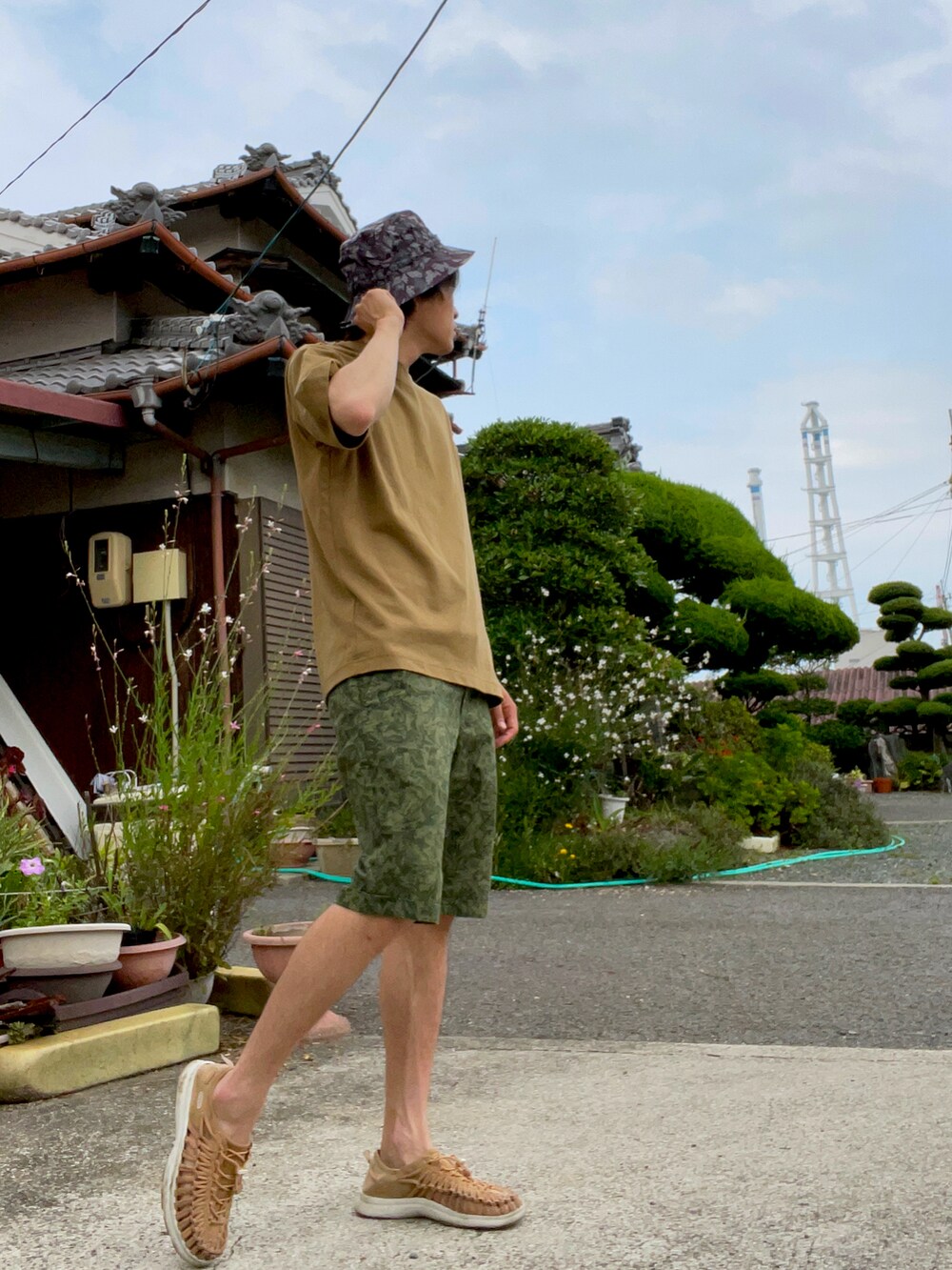 ブラウン系のTシャツ/カットソー、グリーン系のパンツ、ブラウン系のサンダルを着用したメンズの夏コーディネートの2枚目の写真