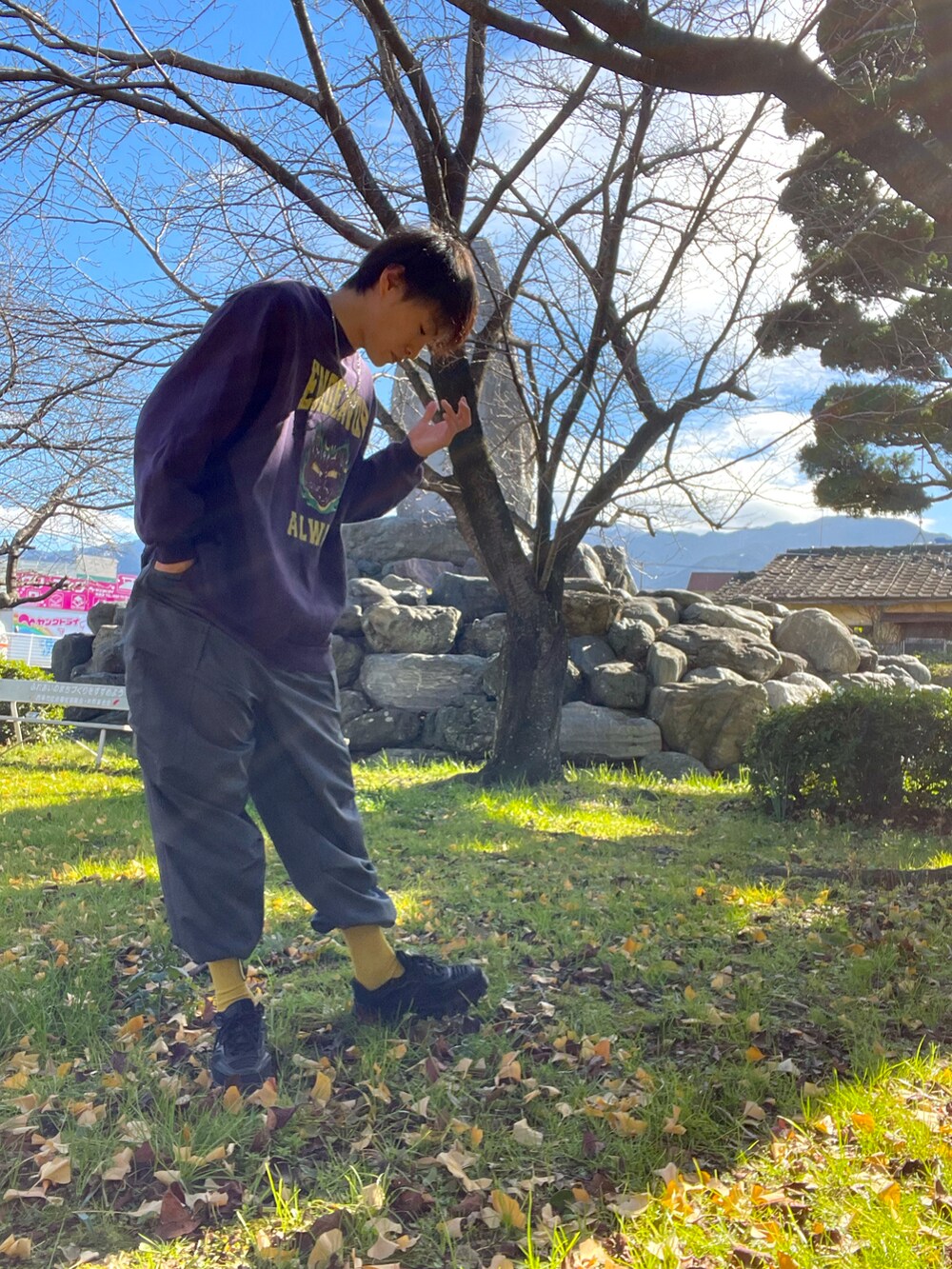 パープル系のスウェット、グリーン系のカーゴパンツ、ブラック系のスニーカーを着用したメンズの冬コーディネートの2枚目の写真