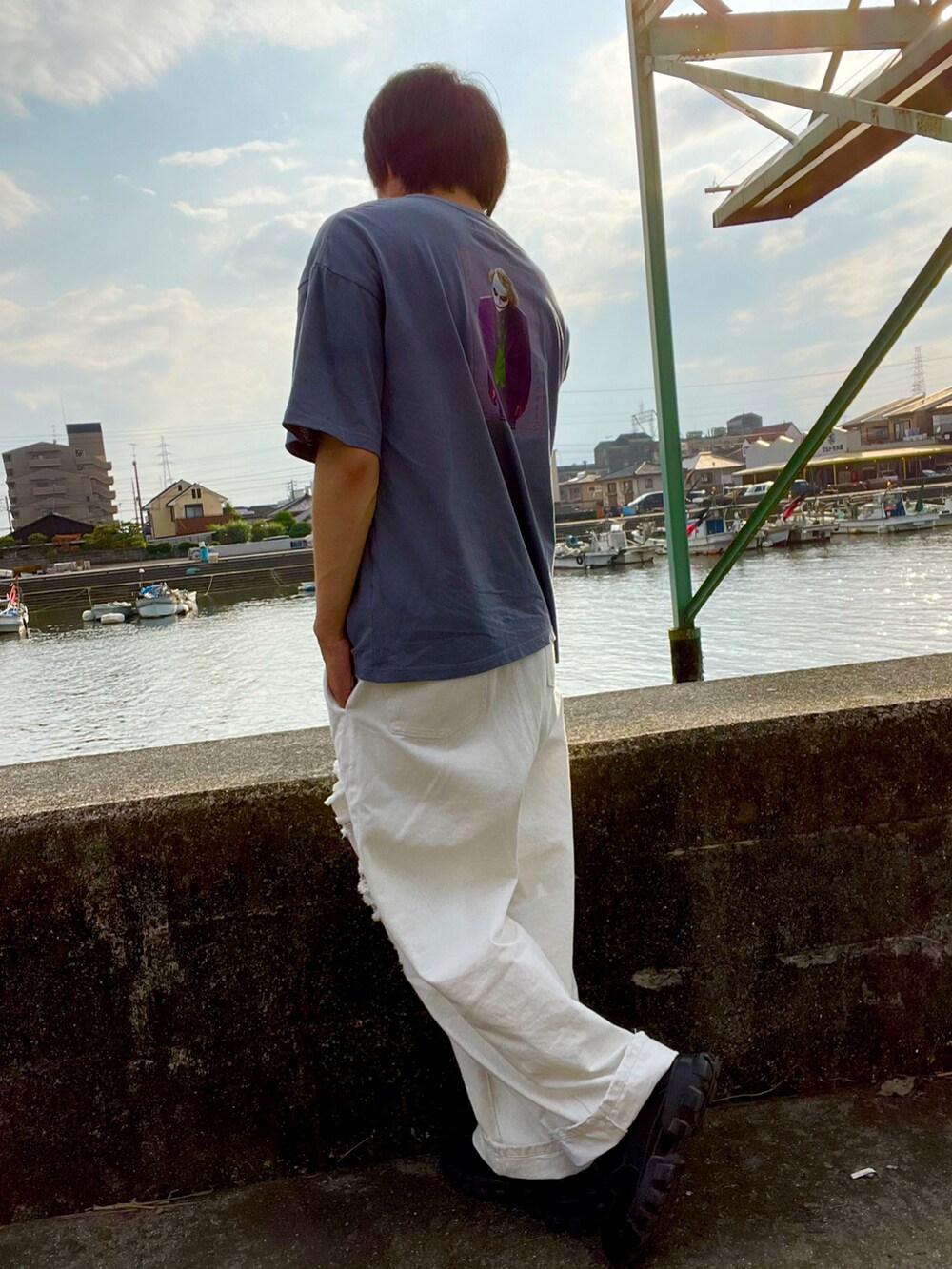 ブルー系のTシャツ/カットソー、ホワイト系のデニムパンツ、ブラック系のスニーカーを着用したメンズの夏コーディネートの2枚目の写真