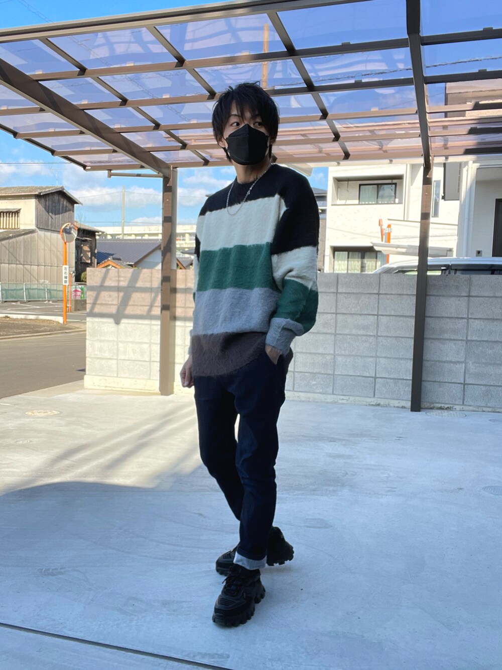 ブラック系のダウンジャケット/コート、ブラック系のニット/セーター、ブルー系のその他パンツを着用したメンズの冬コーディネートの2枚目の写真