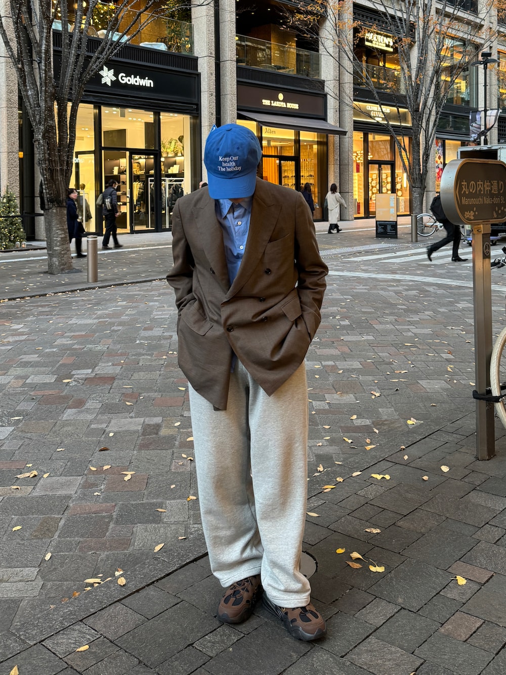 ブラウン系のテーラードジャケット、ブルー系のシャツ/ブラウス、グレー系のスウェットパンツを着用したメンズの冬コーディネートの2枚目の写真