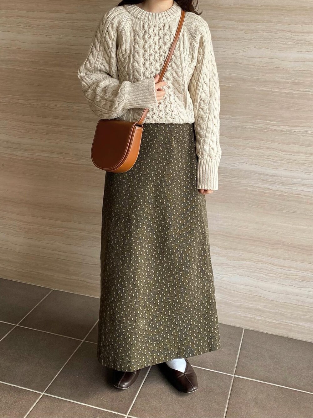 ブラウン系のパンプス、グリーン系のスカート、ホワイト系のニット/セーターを着用したレディースの冬コーディネートの2枚目の写真