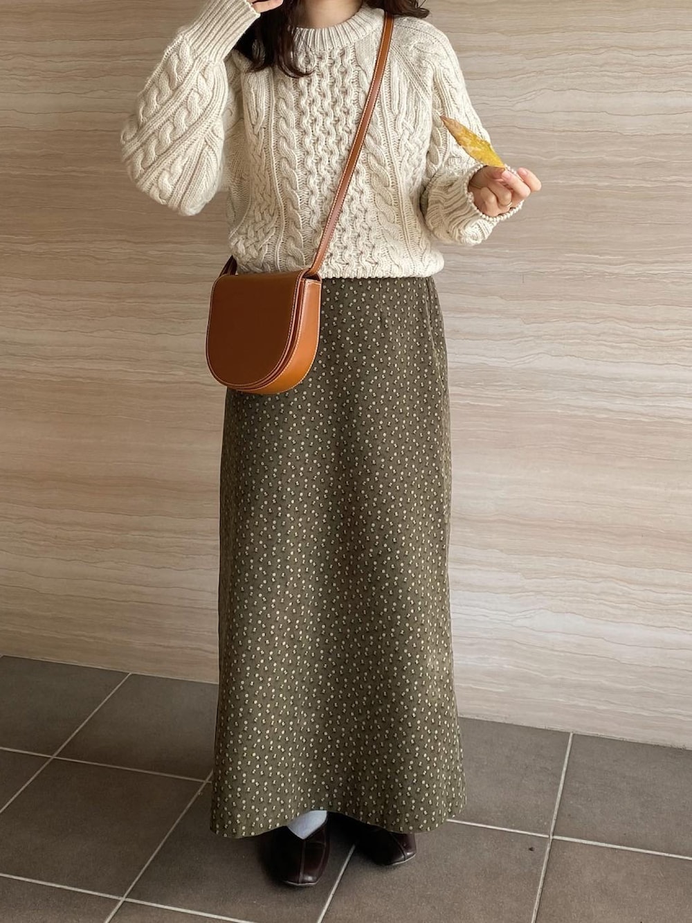 ブラウン系のパンプス、グリーン系のスカート、ホワイト系のニット/セーターを着用したレディースの冬コーディネートの3枚目の写真