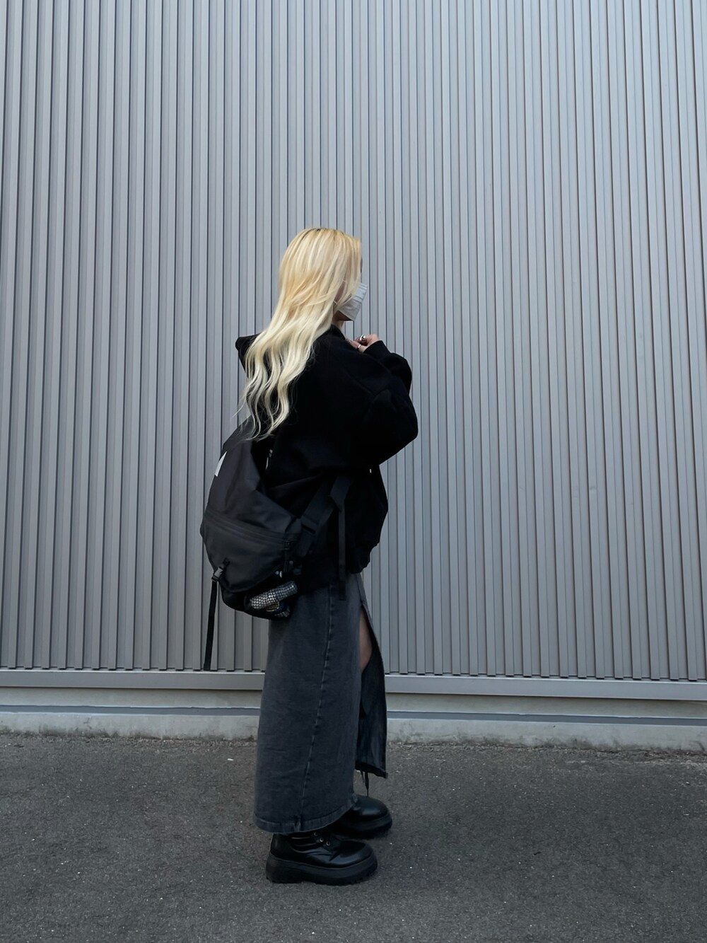 ブラック系のパーカー、ブラック系のデニムスカート、ブラック系のブーツを着用したレディースの冬コーディネートの2枚目の写真