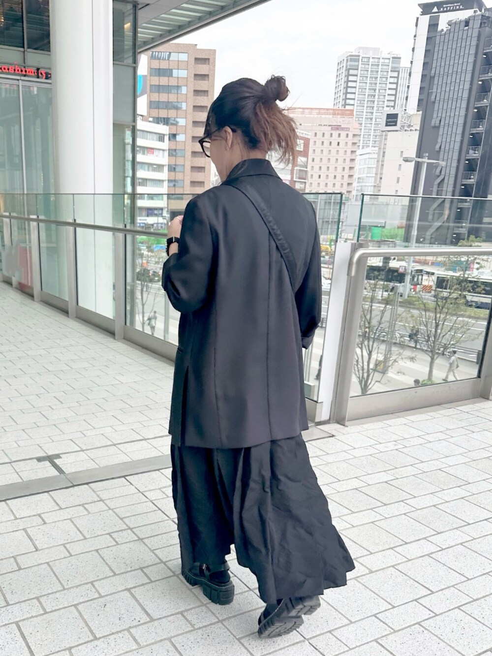 ブラック系のテーラードジャケット、ブラック系のTシャツ/カットソー、ブラック系のジャンパースカートを着用したレディースの春コーディネートの4枚目の写真