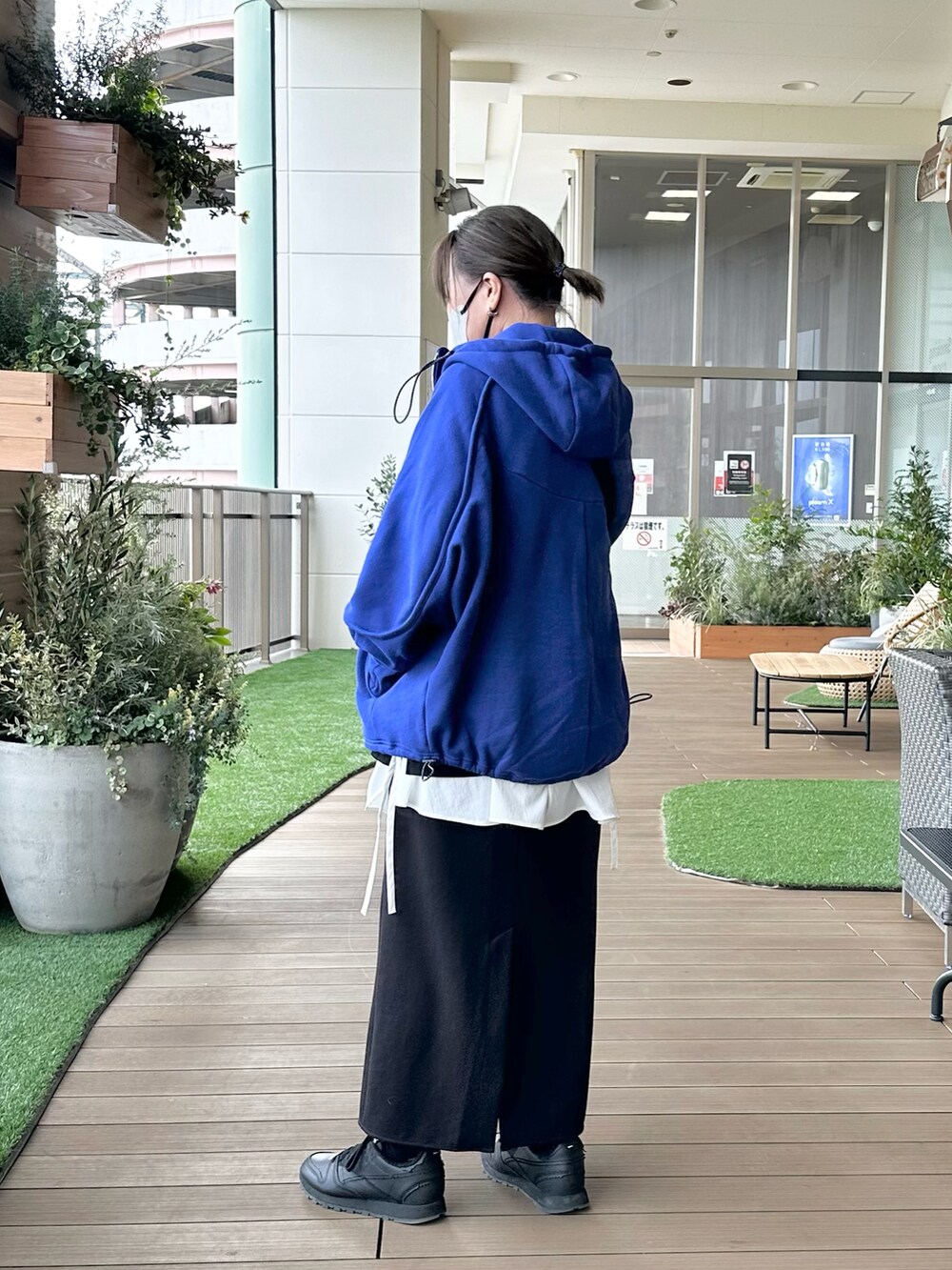ブルー系のパーカー、ブラック系のTシャツ/カットソー、ホワイト系のキャミソールを着用したレディースの春コーディネートの2枚目の写真