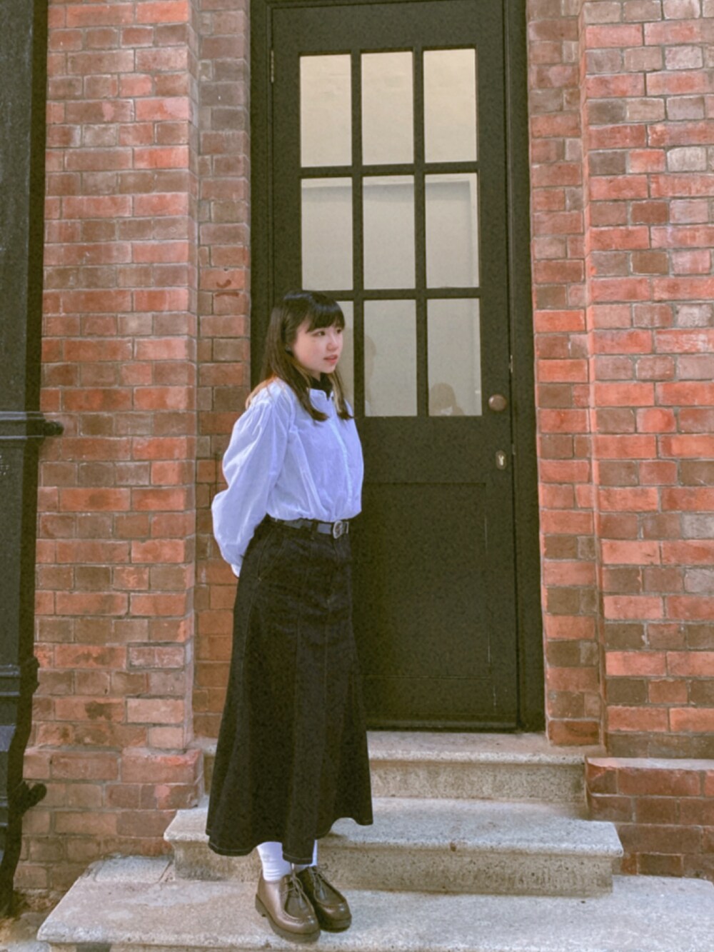 ブラック系のバッグ、グリーン系のシューズを着用したレディースの冬コーディネートの2枚目の写真