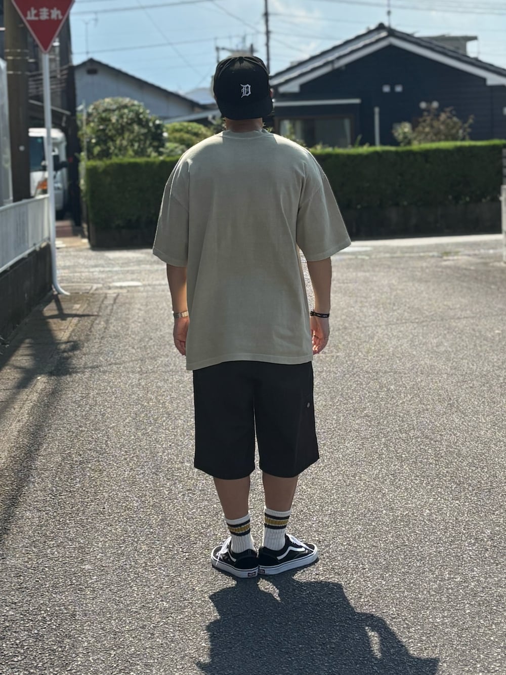 ブラック系のTシャツ/カットソー、ブラック系のチノパンツ、ブラック系のスニーカーを着用したメンズの秋コーディネートの3枚目の写真