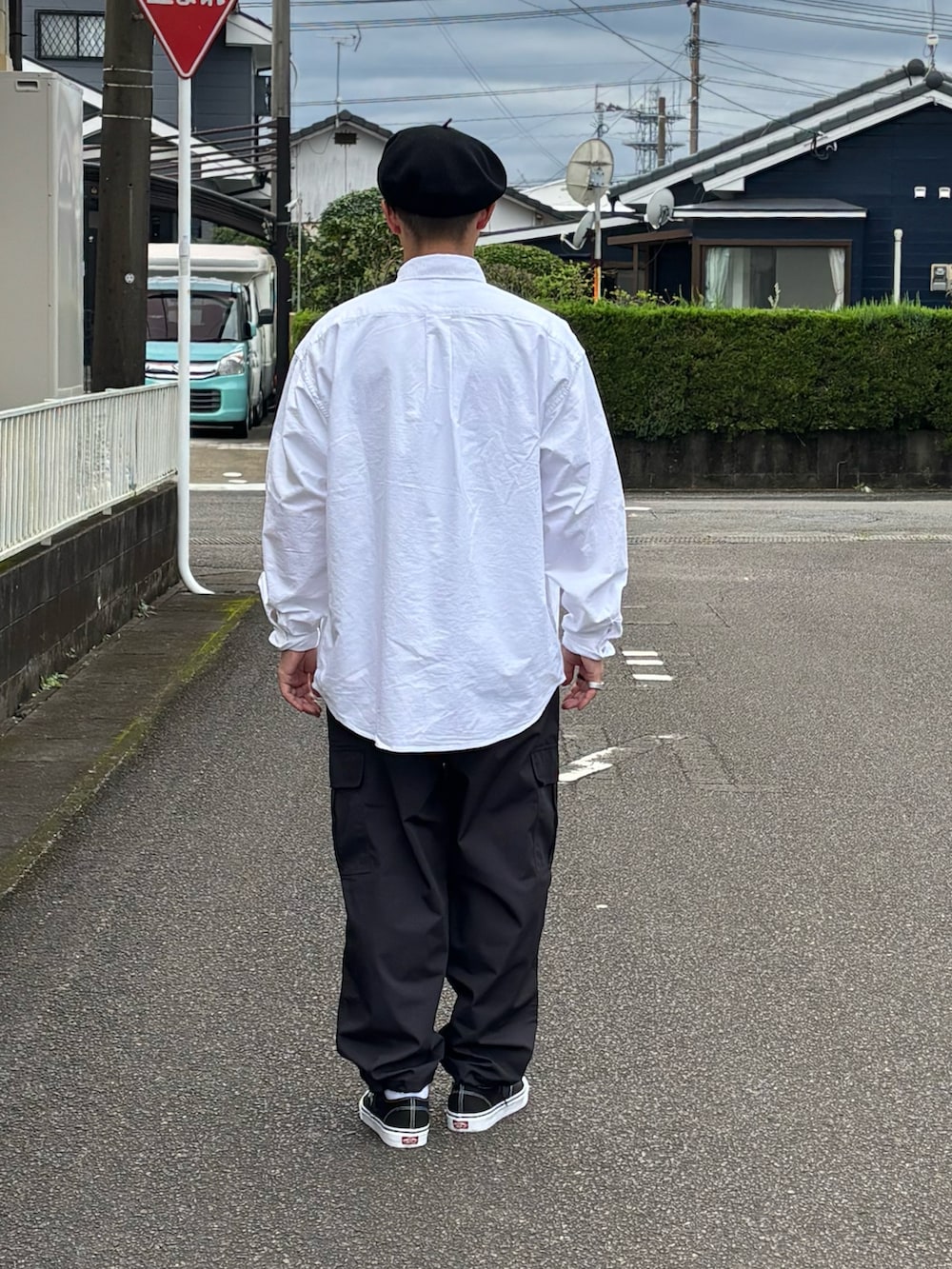 ブラック系のスニーカー、ホワイト系のシャツ/ブラウス、ベージュ系のカーゴパンツを着用したメンズの秋コーディネートの4枚目の写真