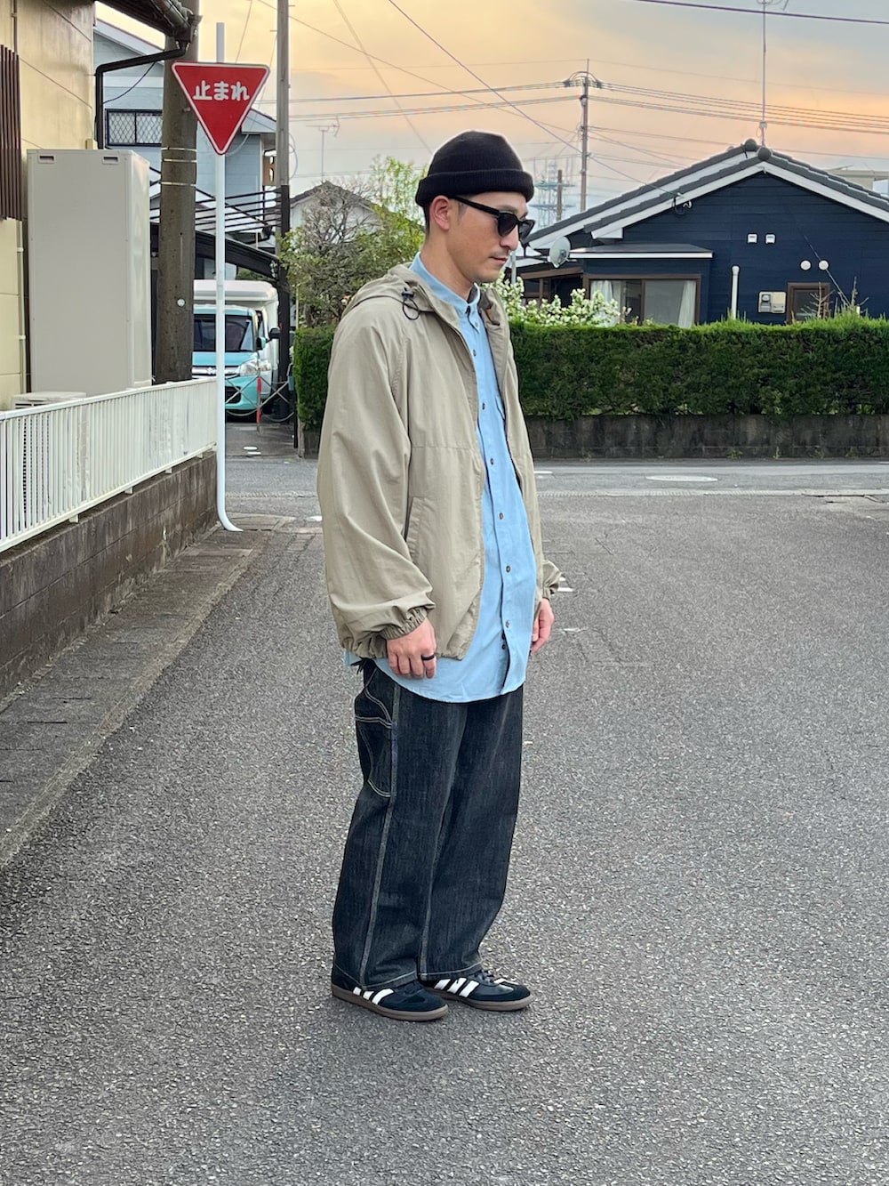 ベージュ系のトップス、ブルー系のシャツ/ブラウス、ブラック系のデニムパンツを着用したメンズの春コーディネートの2枚目の写真