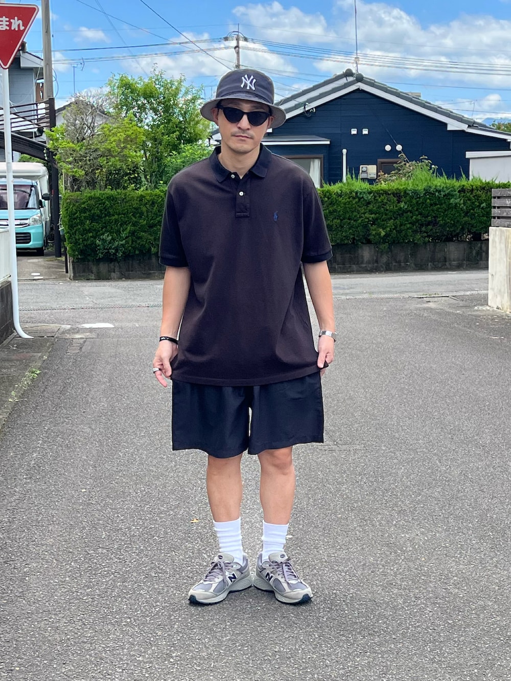 グレー系のスニーカー、ブラウン系のポロシャツ、ブルー系のその他パンツを着用したメンズの夏コーディネートの2枚目の写真