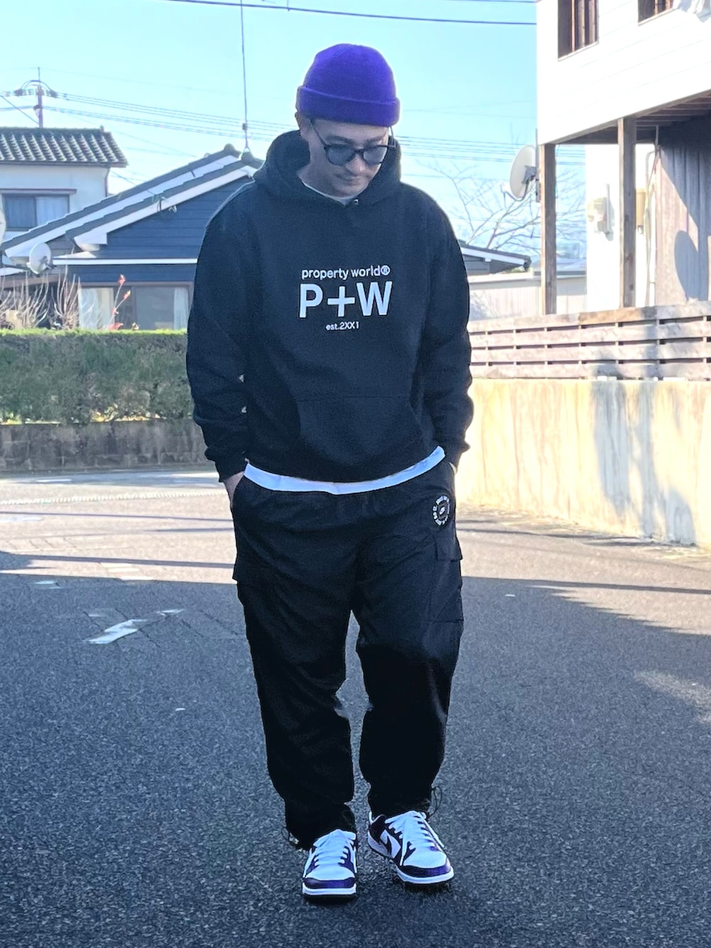 ホワイト系のTシャツ/カットソー、ブラック系のパンツ、パープル系のスニーカーを着用したメンズの冬コーディネートの2枚目の写真