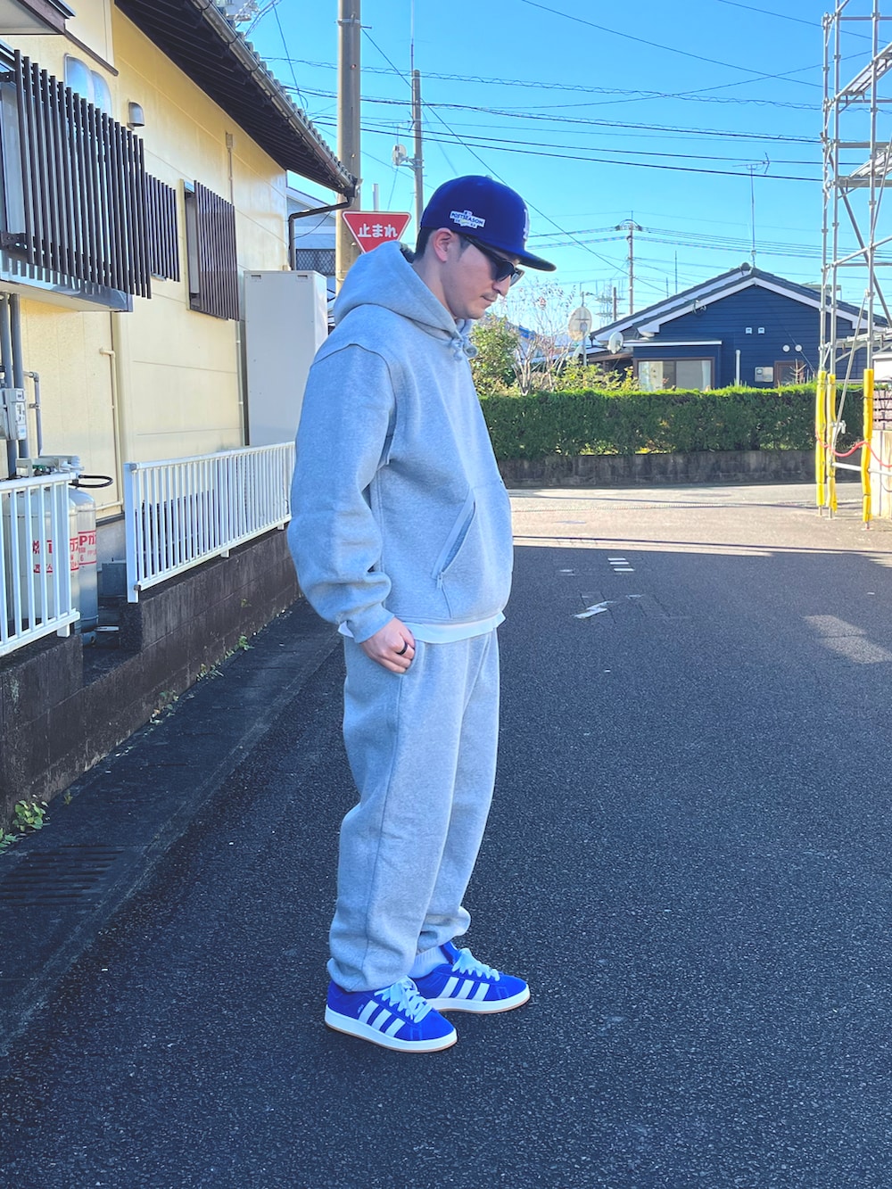 グレー系のパーカー、グレー系のスウェットパンツ、ホワイト系のTシャツ/カットソーを着用したメンズの冬コーディネートの2枚目の写真